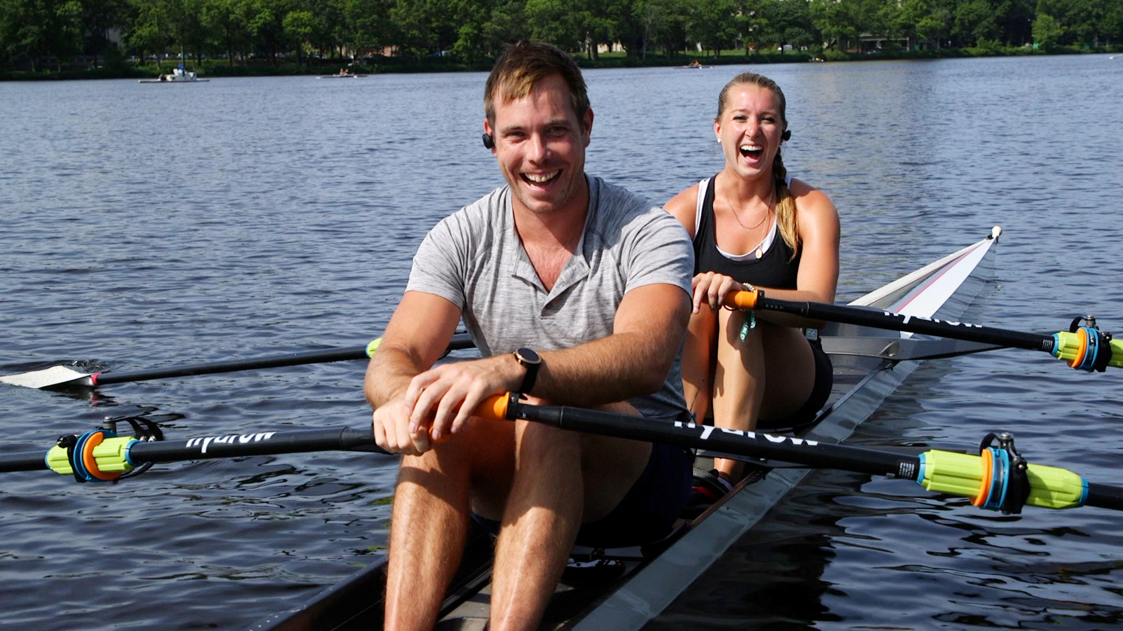 Two rowers laugh during a rowing machine workout