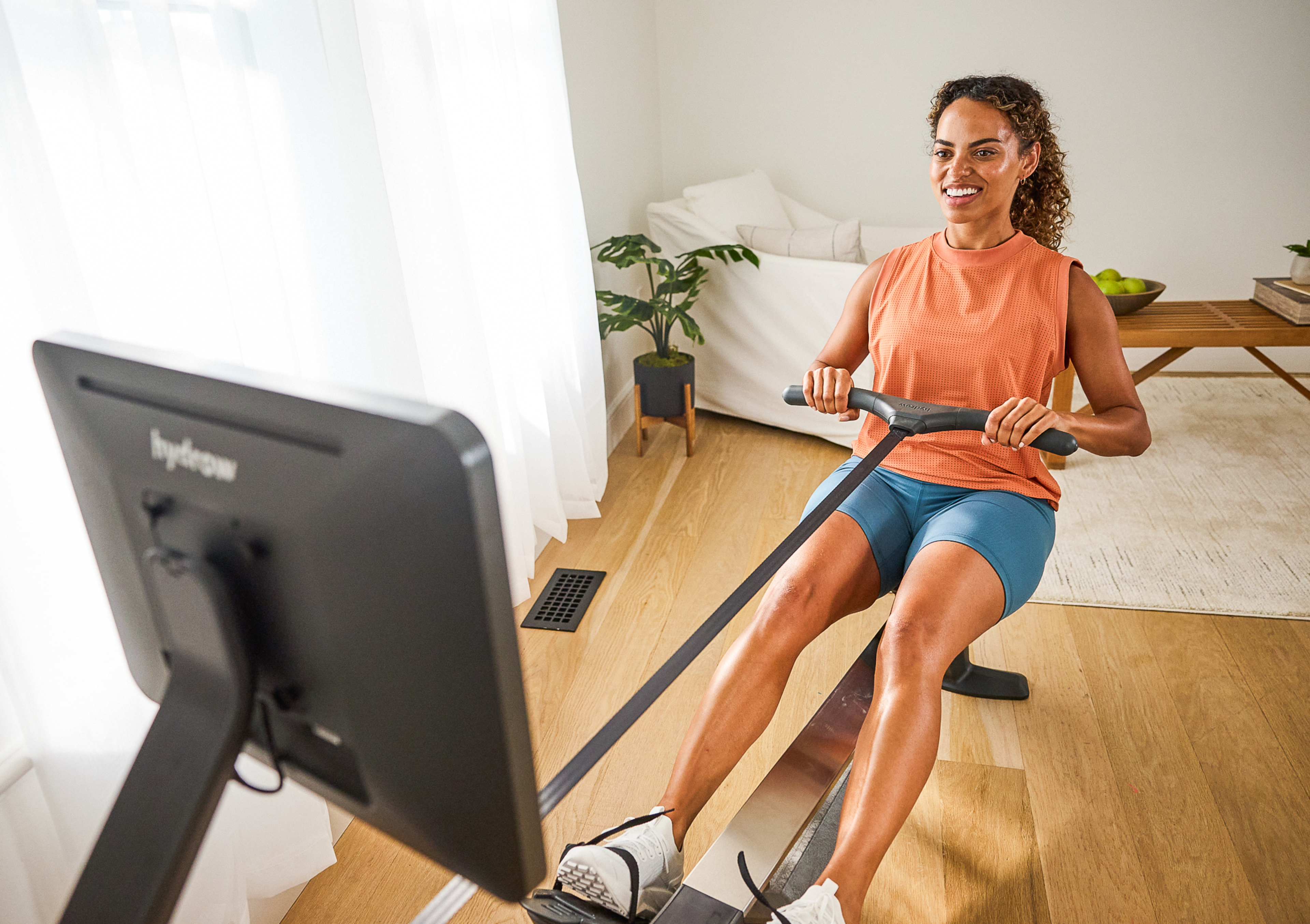 Woman does a quick at-home workout on a rowing machine.
