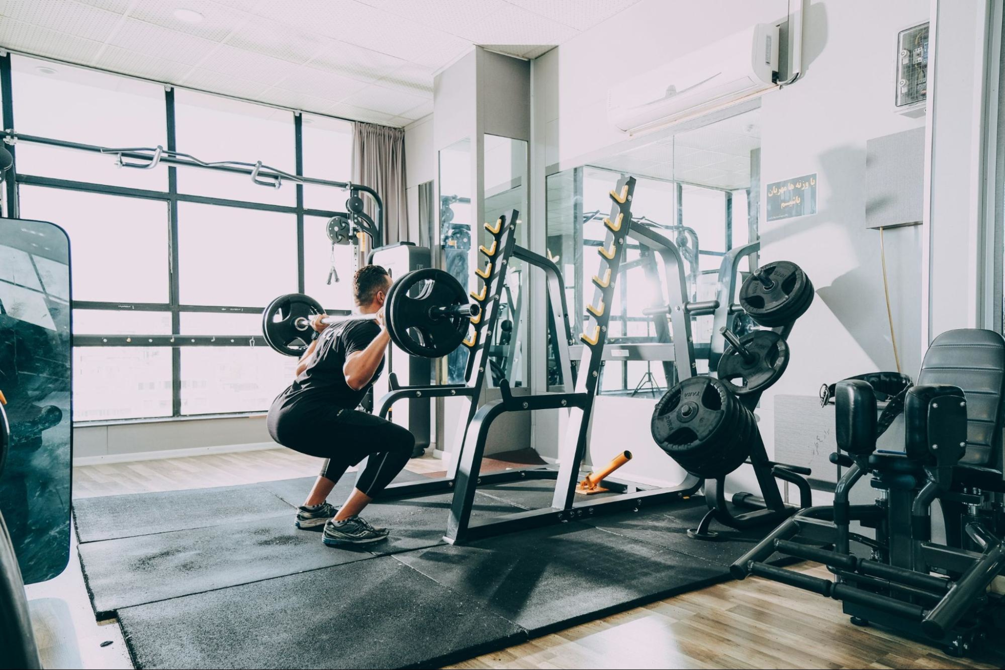 Man does a weights workout at a gym after learning about the benefits of a gym membership.