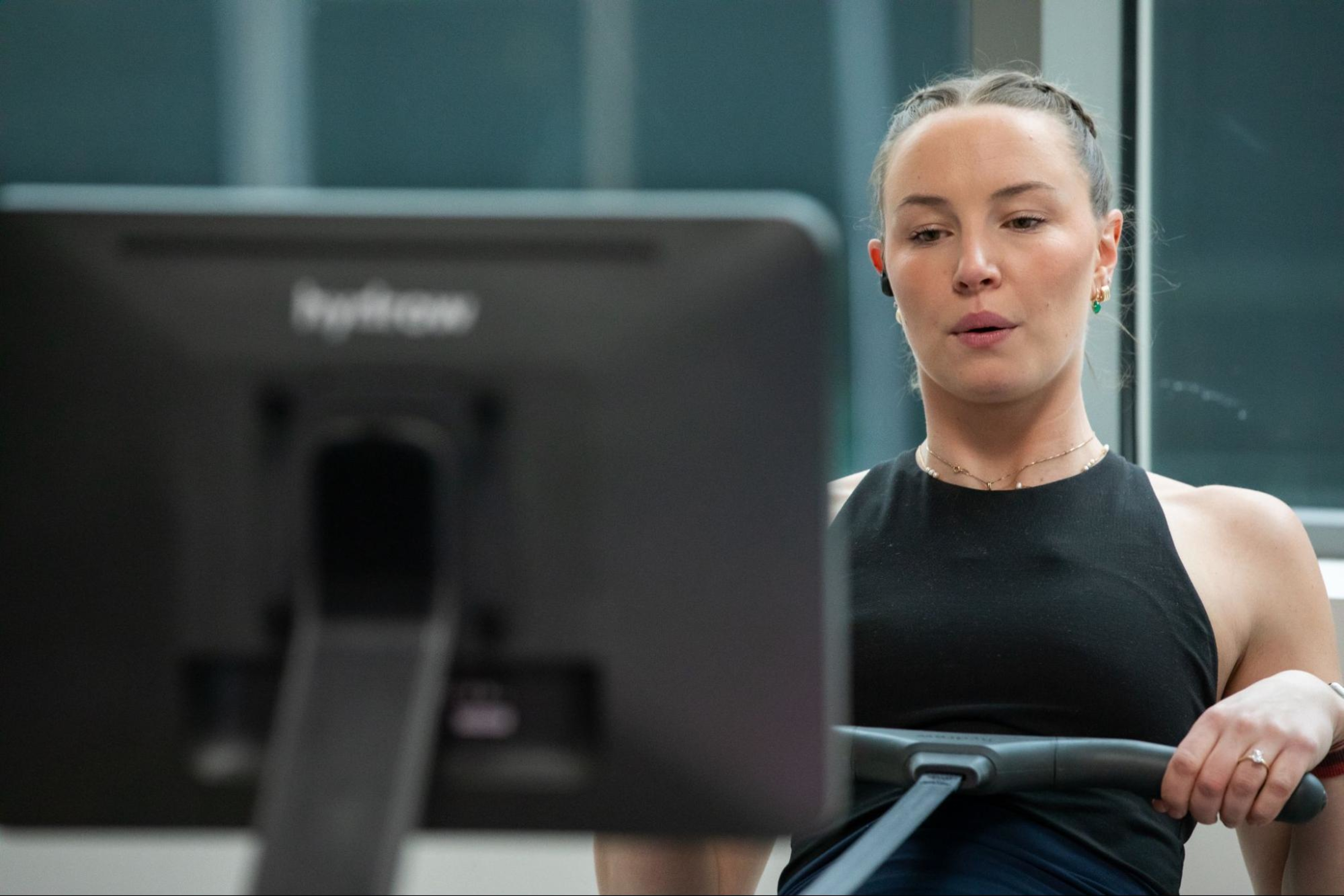Woman works out at a home gym after learning about the costs of a home gym.