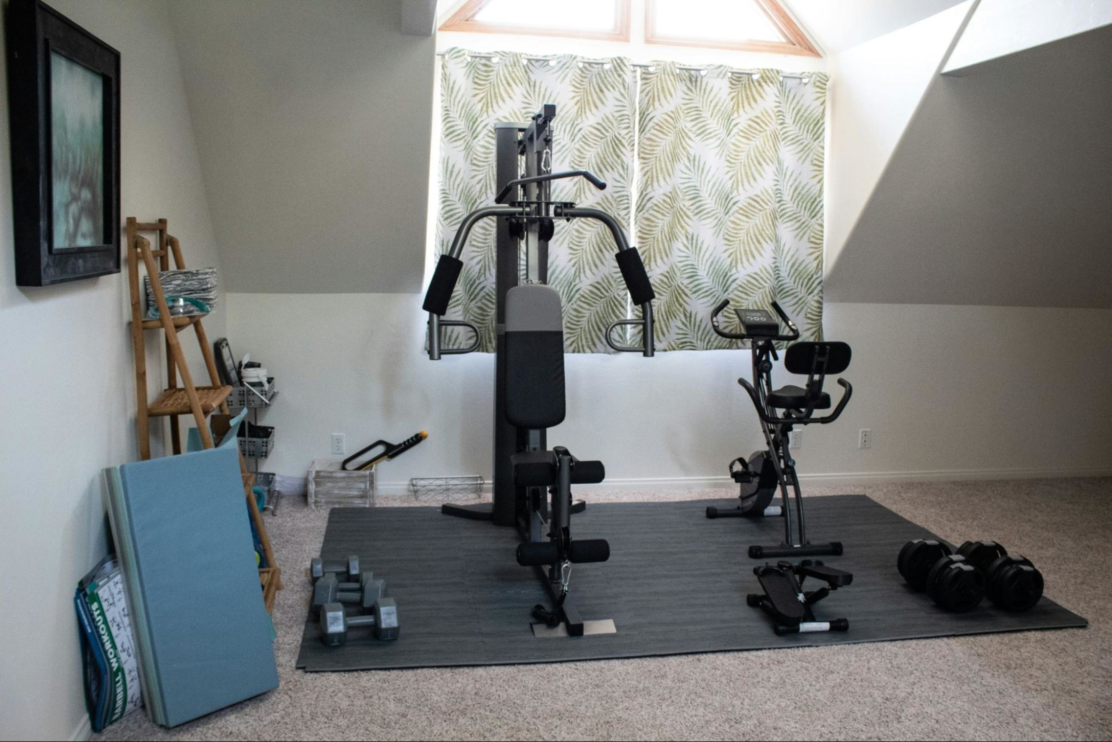 A home gym setup with weight training and an elliptical.