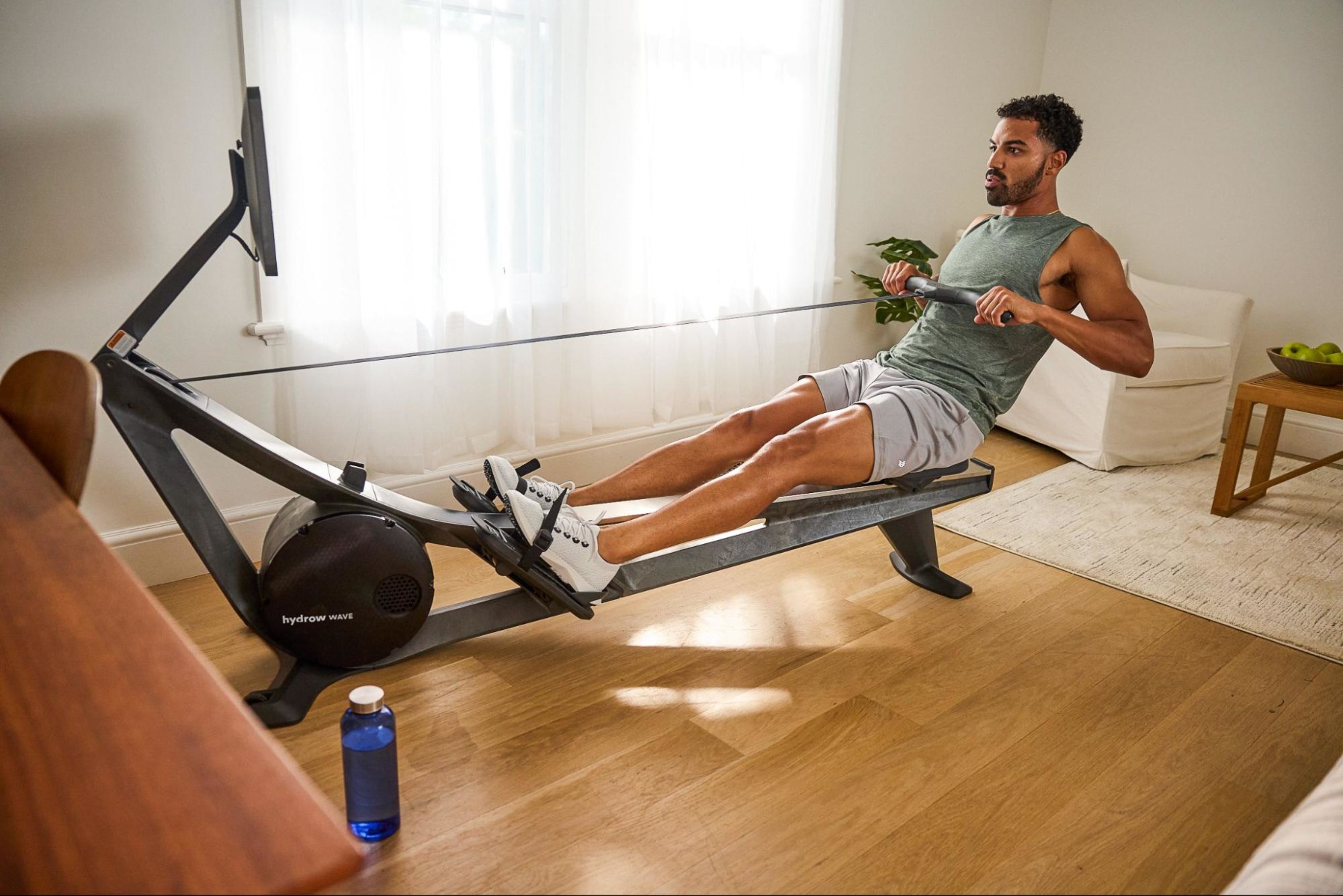 Man does a rowing machine workout after learning about the benefits of working out every day.