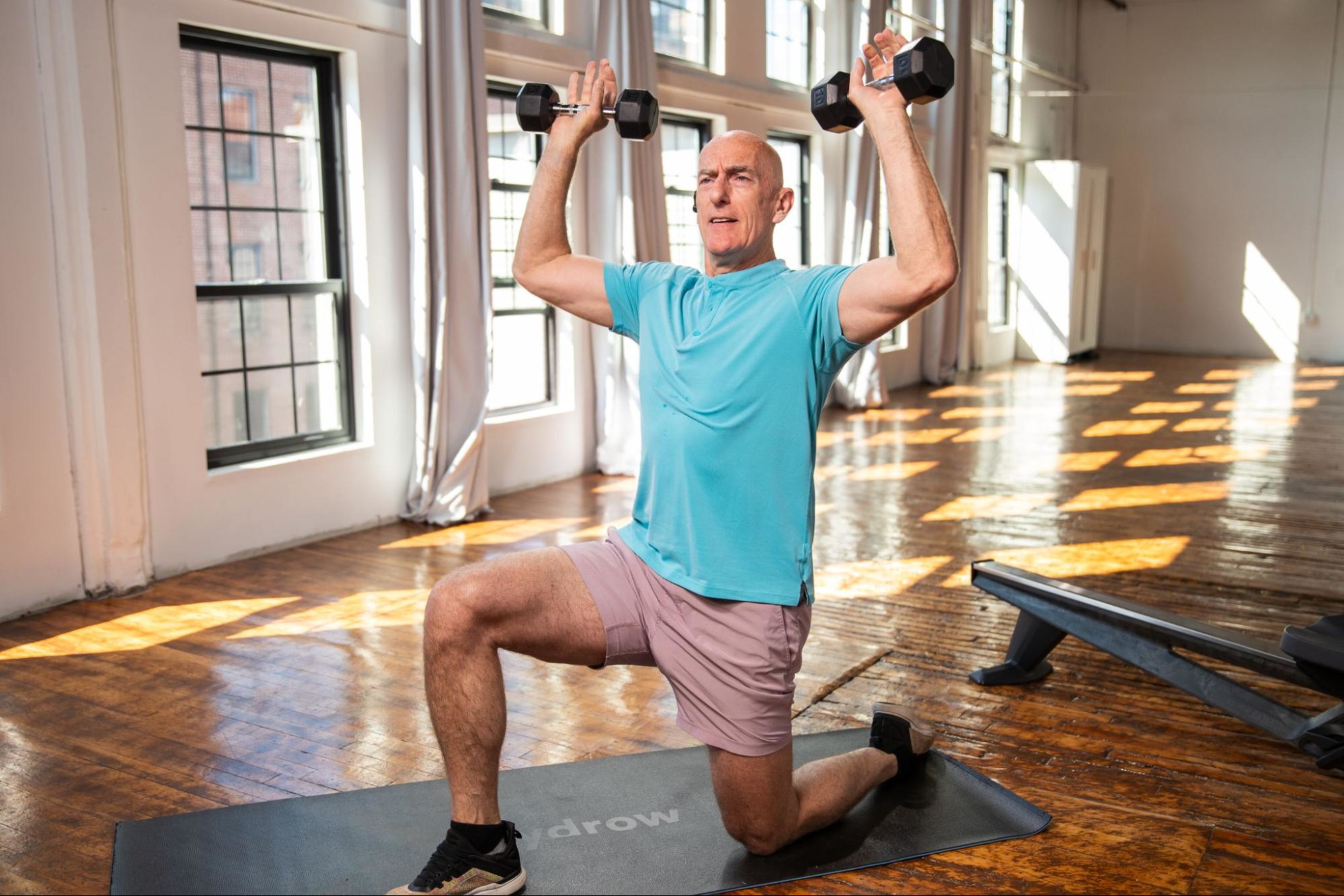 Man does a weights workout after learning the pros and cons of working out every day.