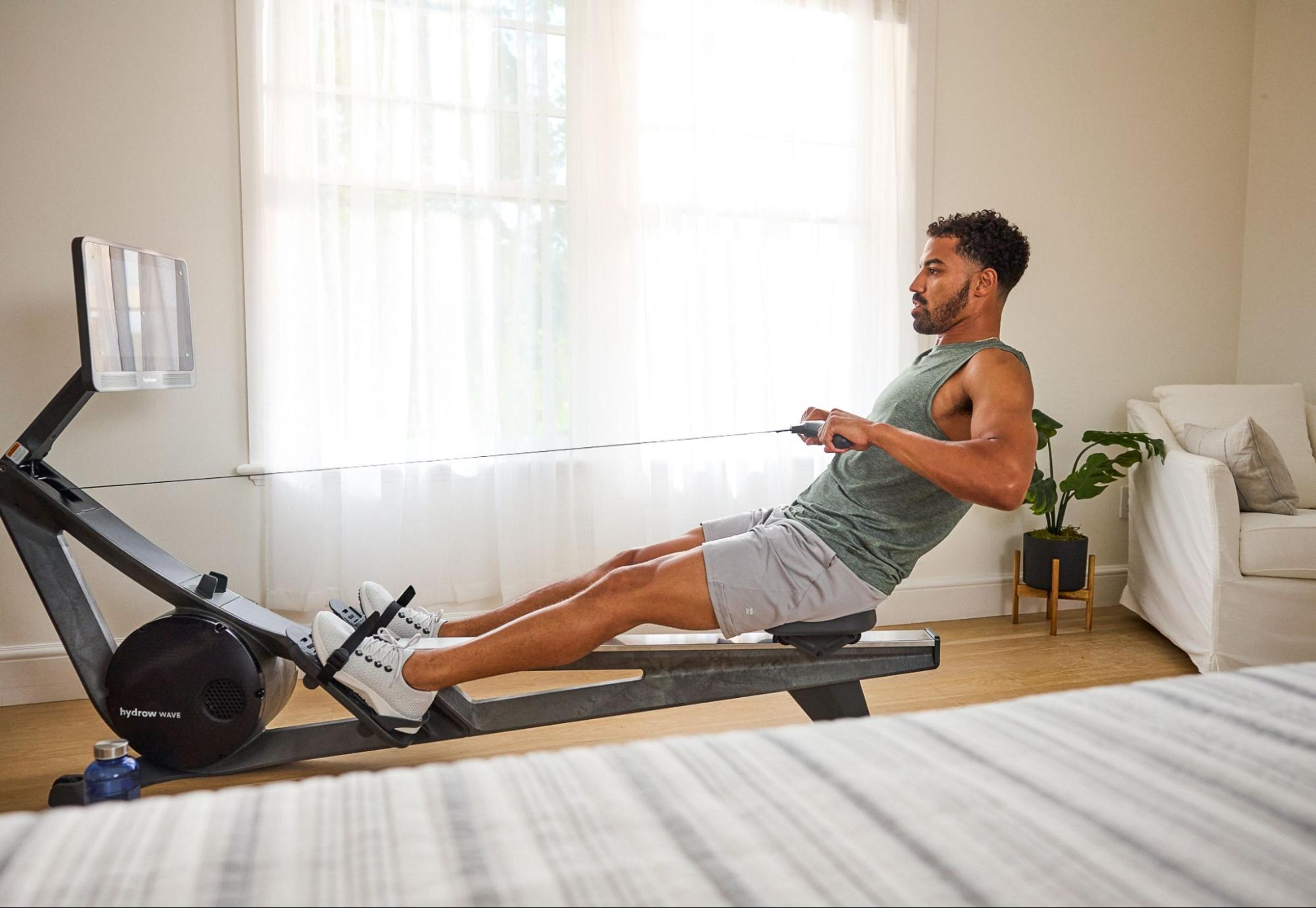 Man uses a rowing machine with shin splints.