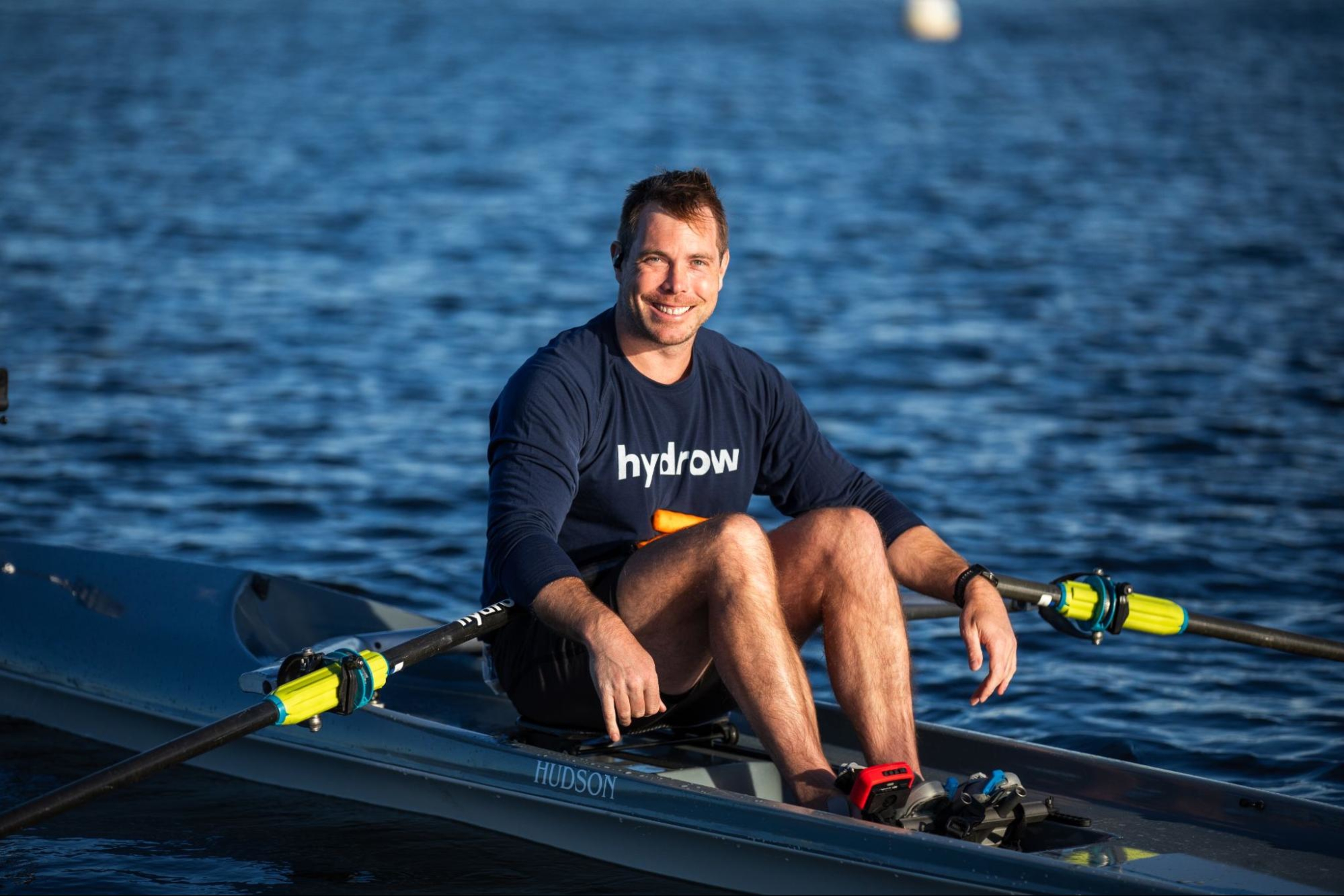 Hydrow Athlete does a rowing workout on the water.