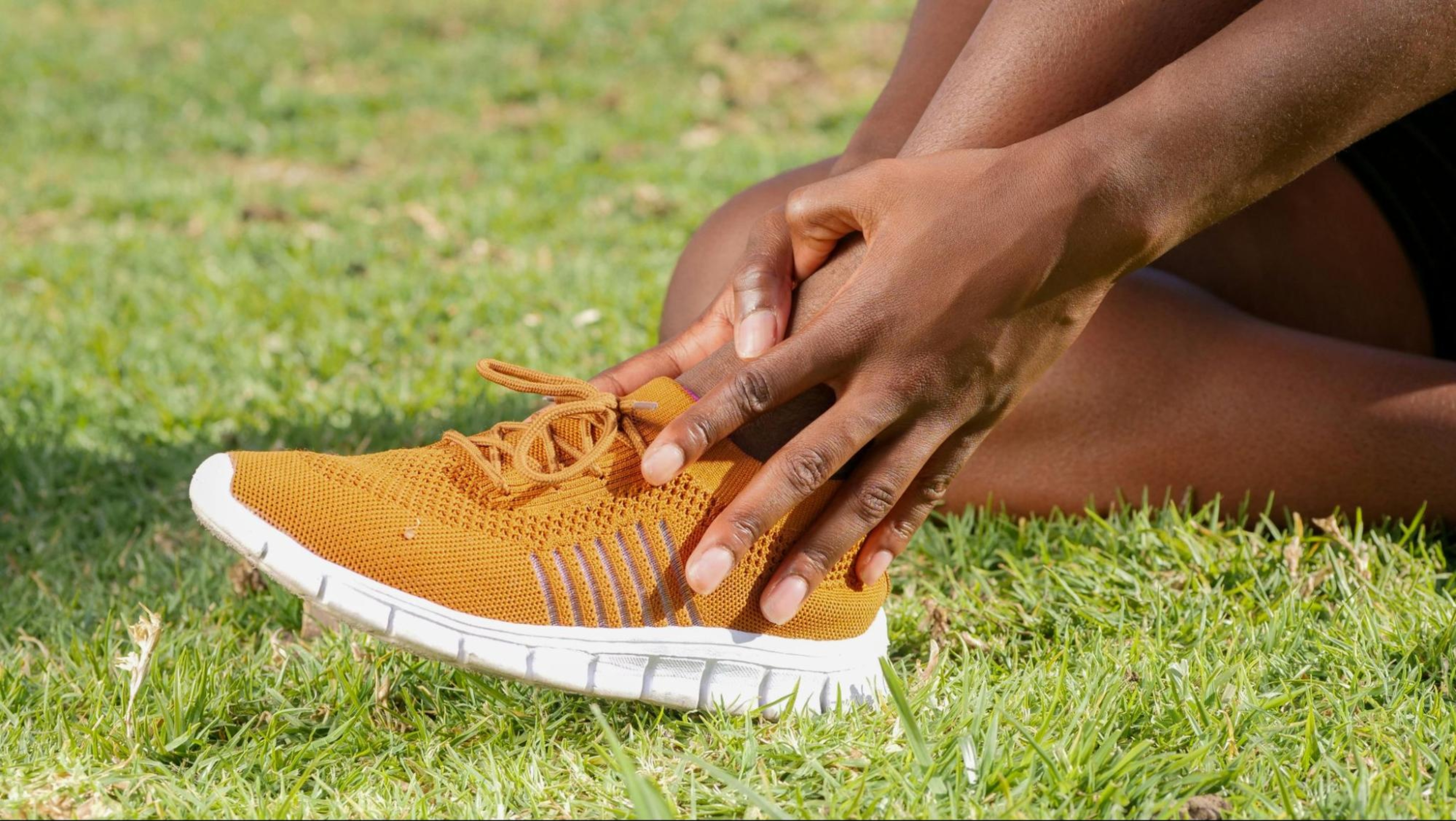 Person holds their shin after experiencing shin splints from exercise.
