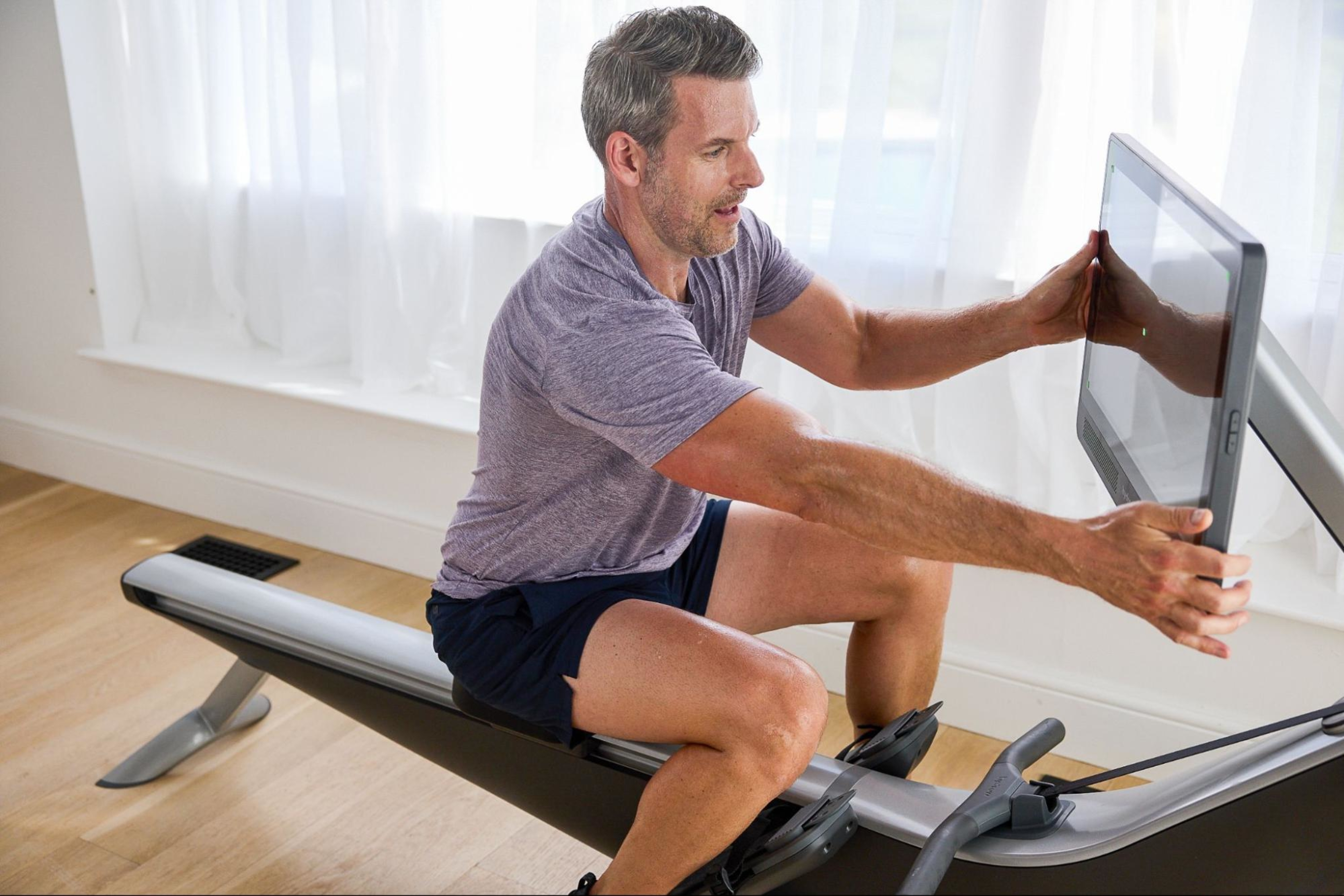 Man assembles his rowing machine at home.