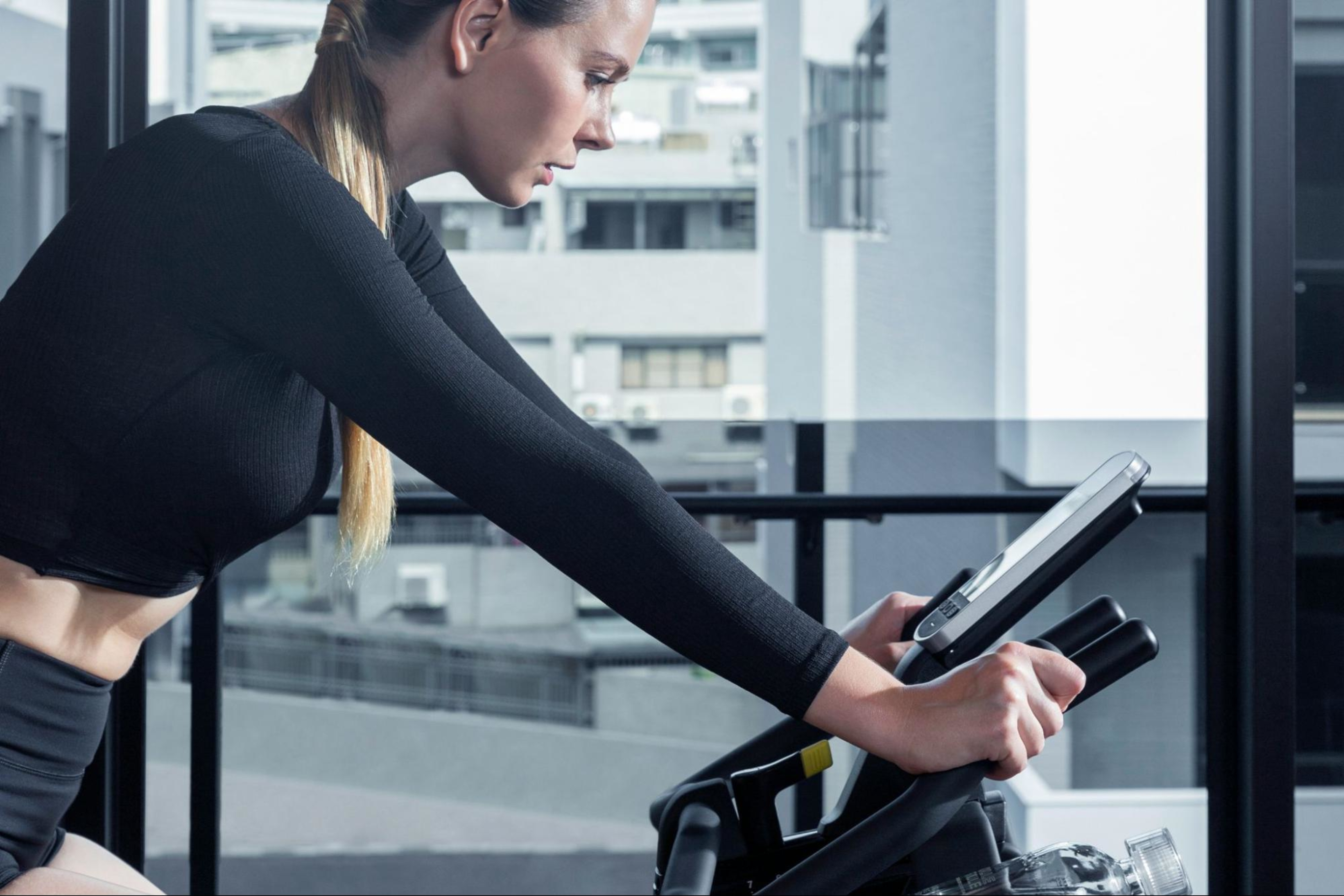 Woman does a cycling workout after learning if she should do cardio or weights first.