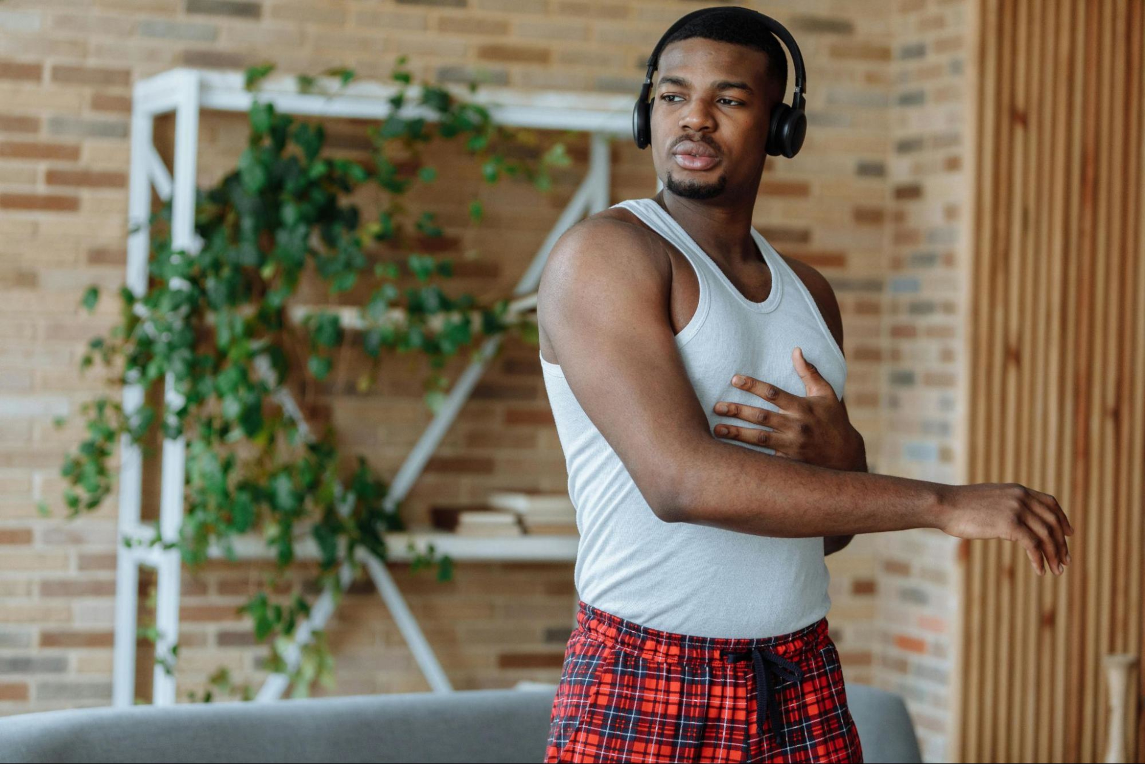 Busy professional man works out wearing headphones at home.