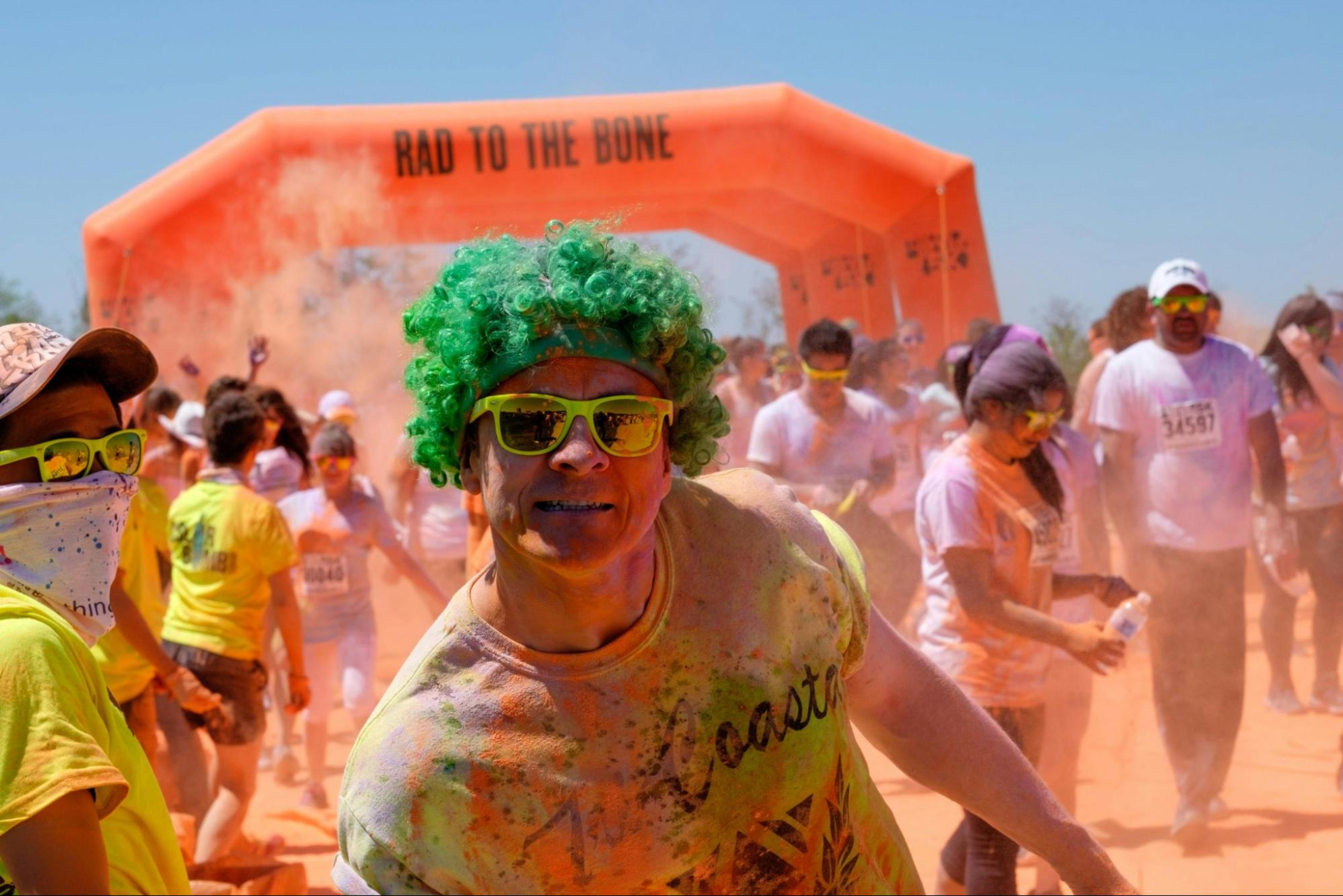Man smiles at the camera after completing a colorful fun run event to make exercise more fun.