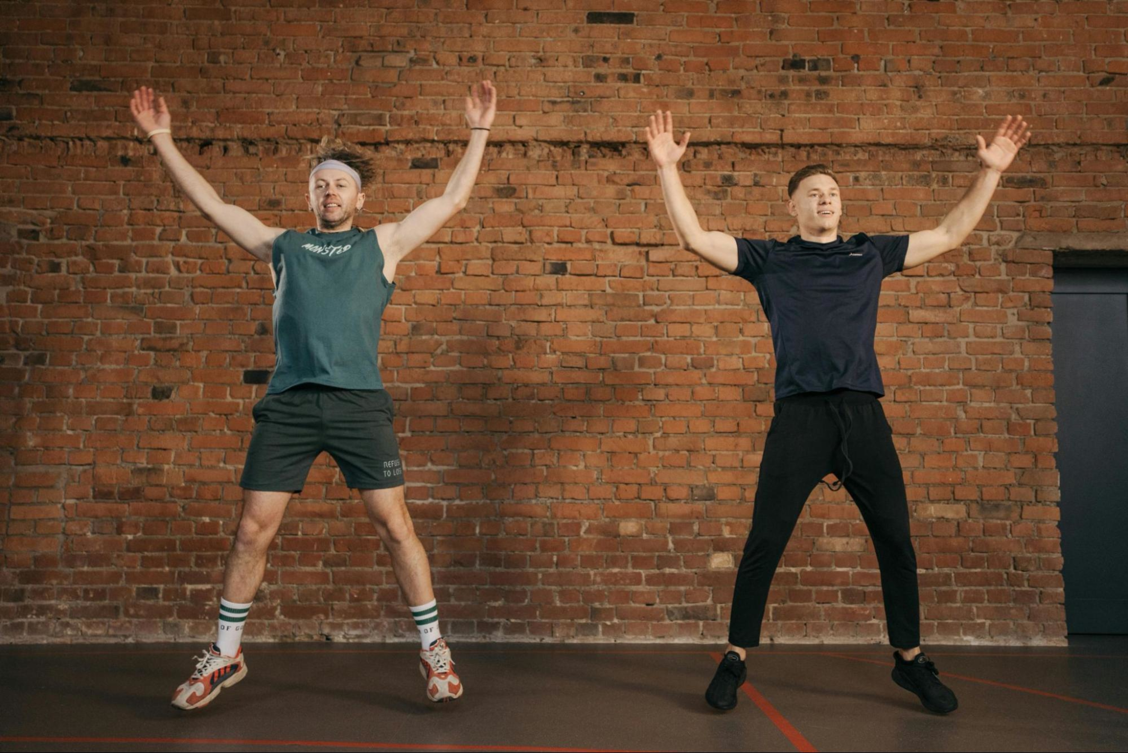 Two men do a full-body circuit training workout in a small space.
