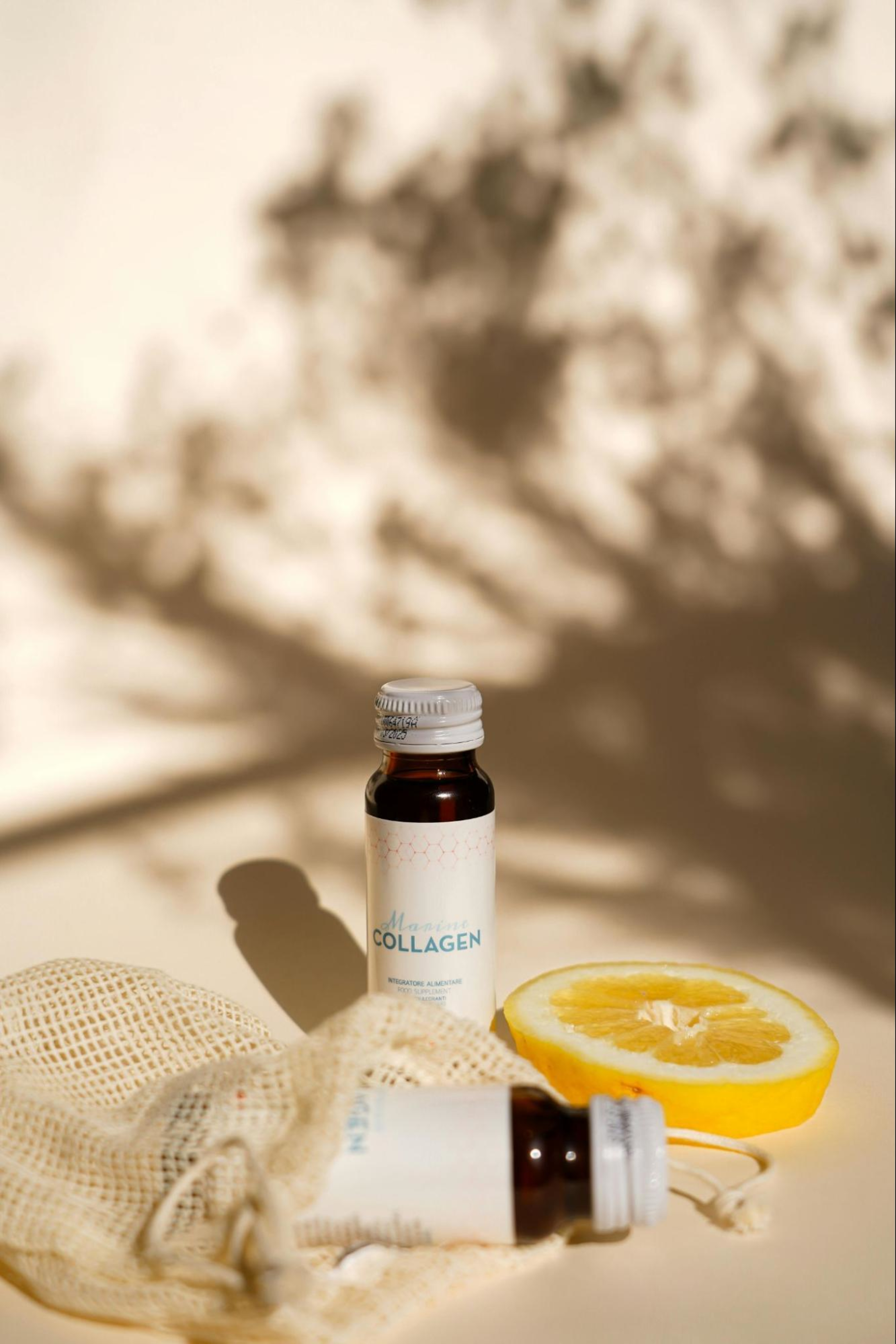 Bottle of collagen next to a lemon.