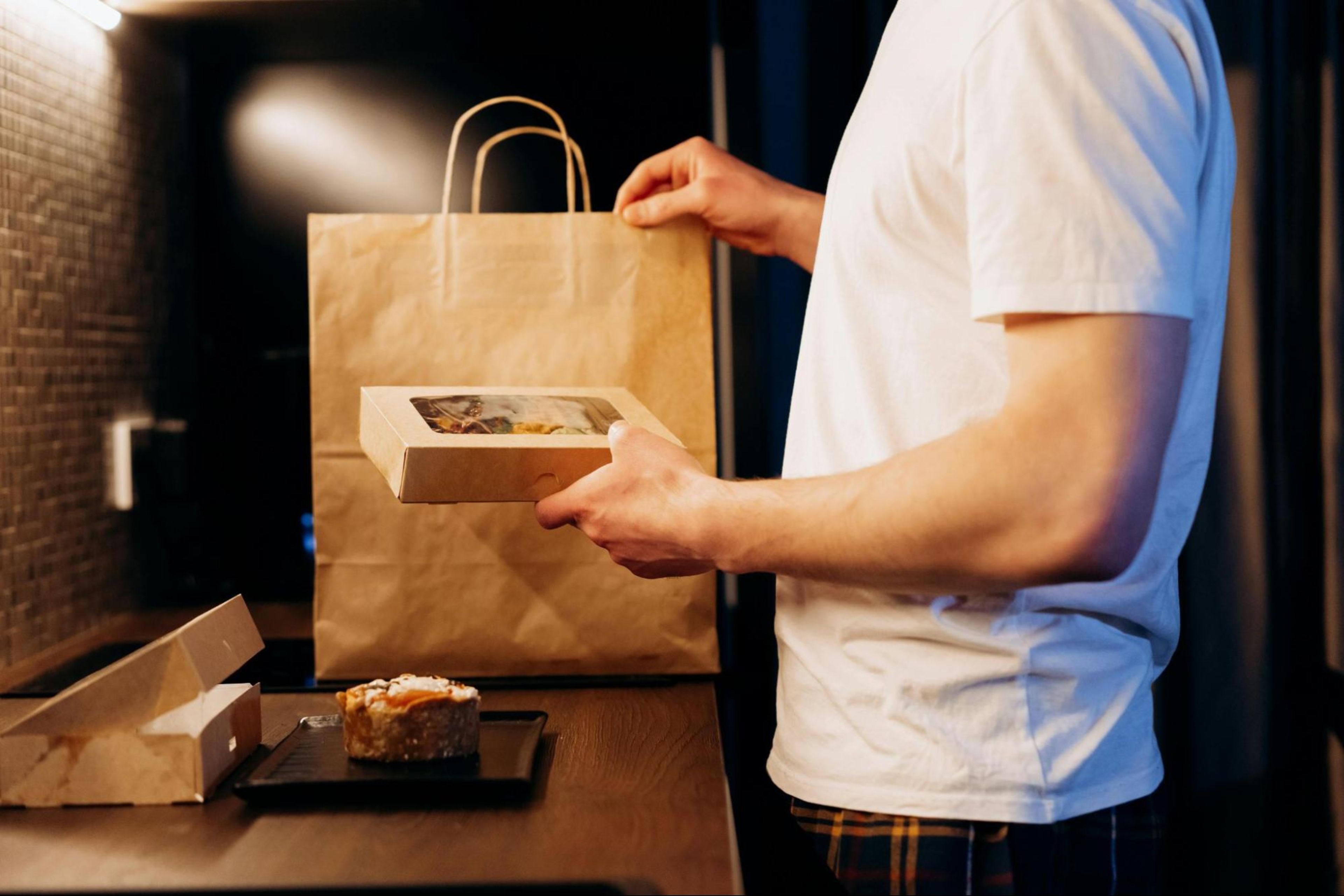 Man unpacks meal delivery in his kitchen.