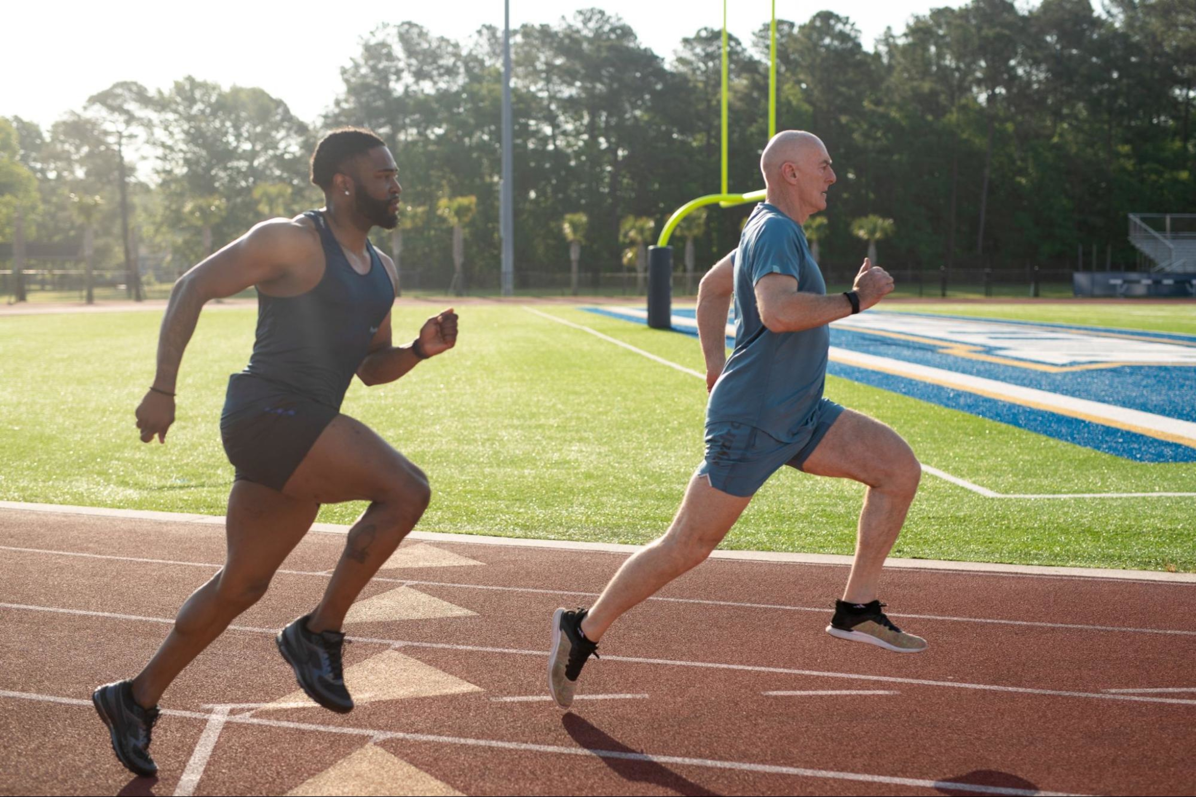 Two men race on a track in a high-intensity workout.
