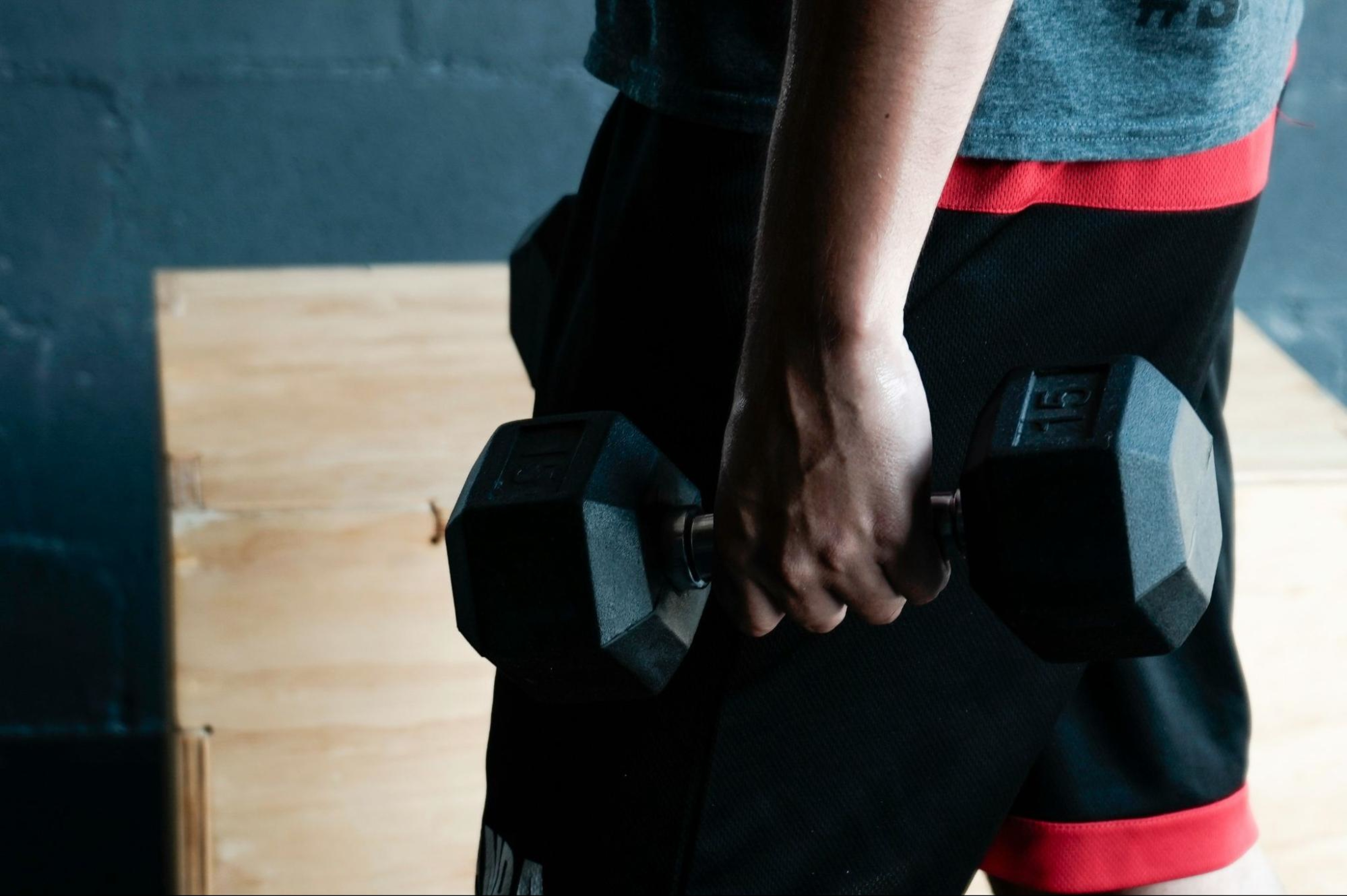 Man carries a dumbbell, a method for combating muscle loss from GLP-1s.