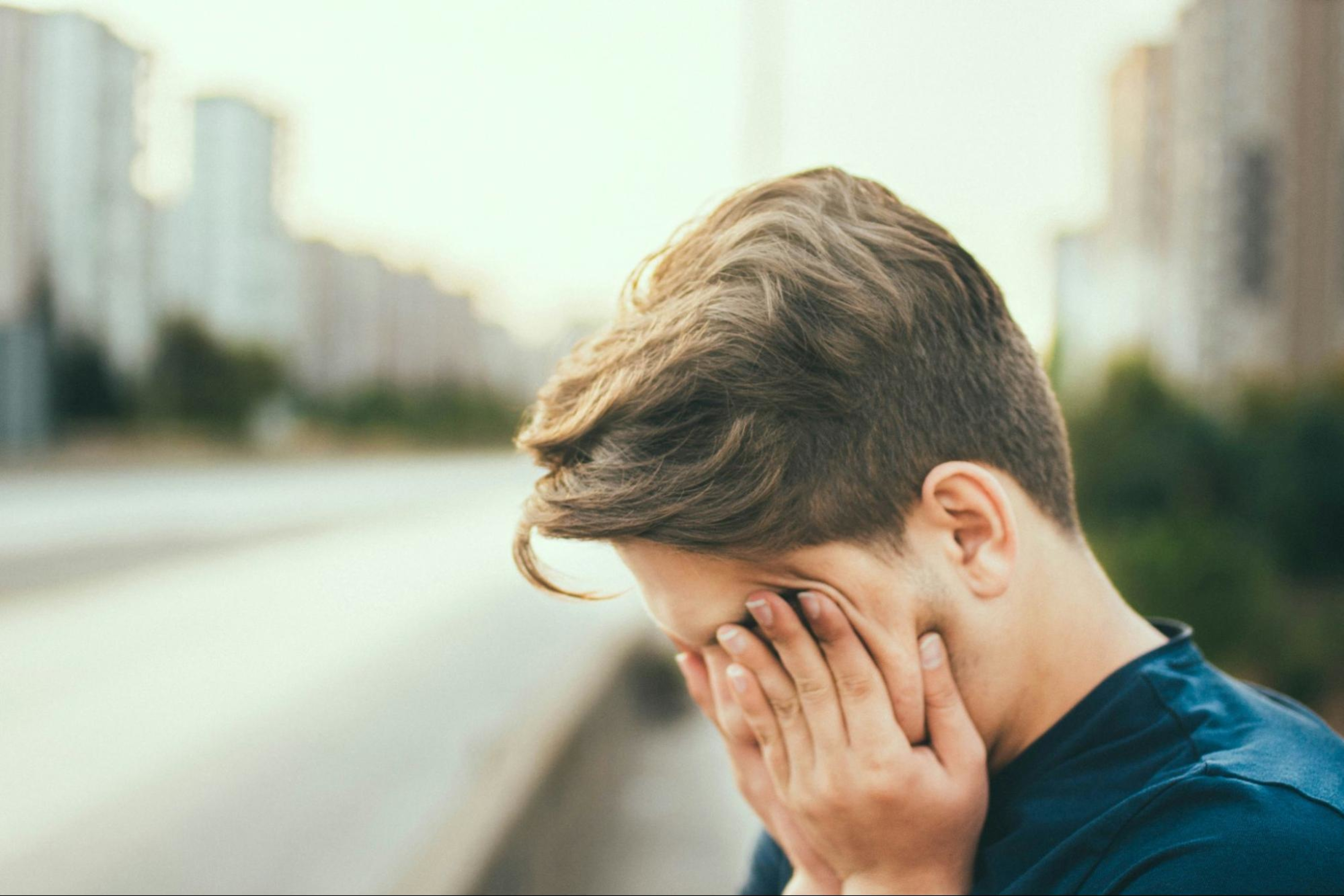Man holds his face because he is fatigued, a sign of muscle loss from GLP-1s.
