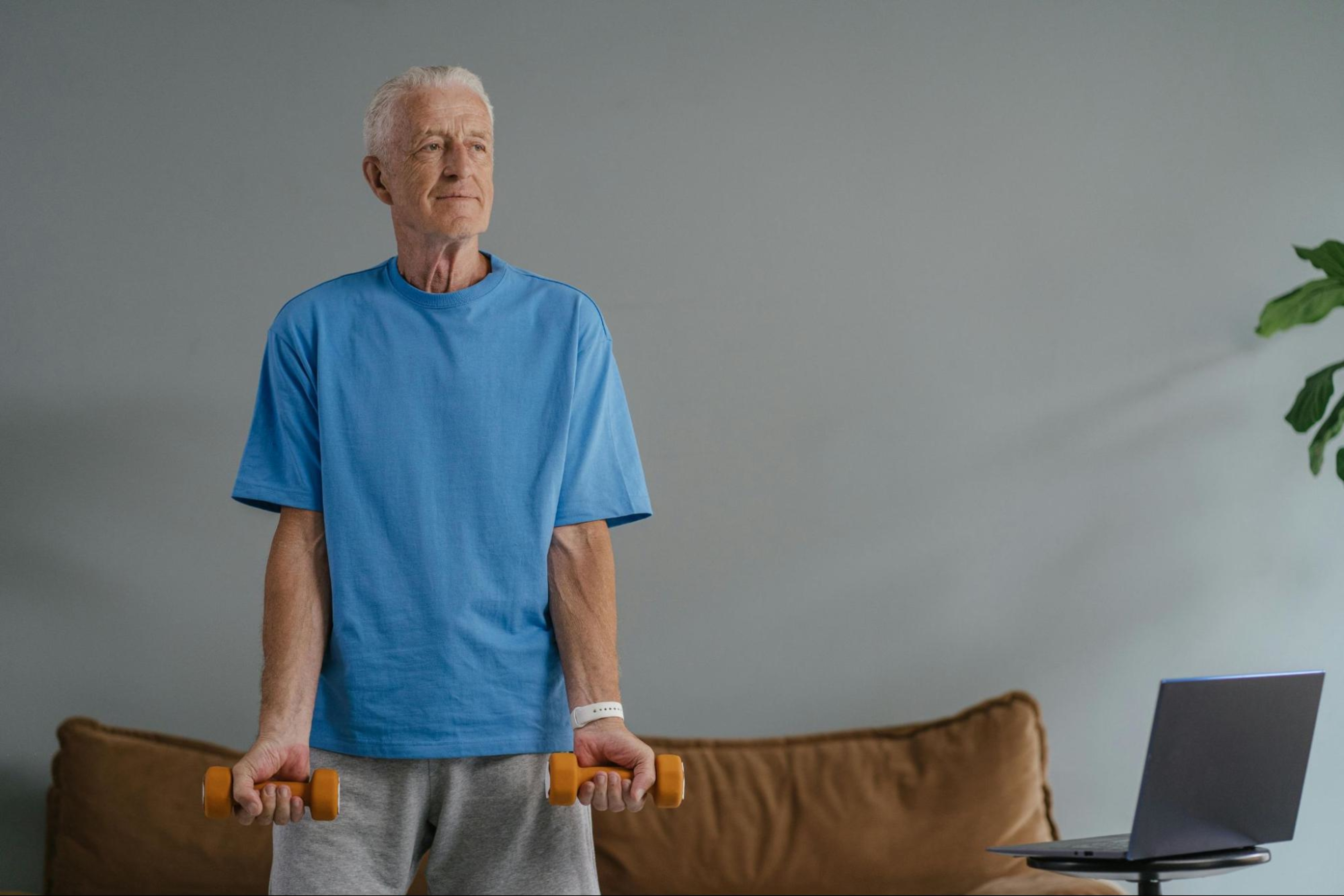 Older man does a functional strength training workout in his living room.