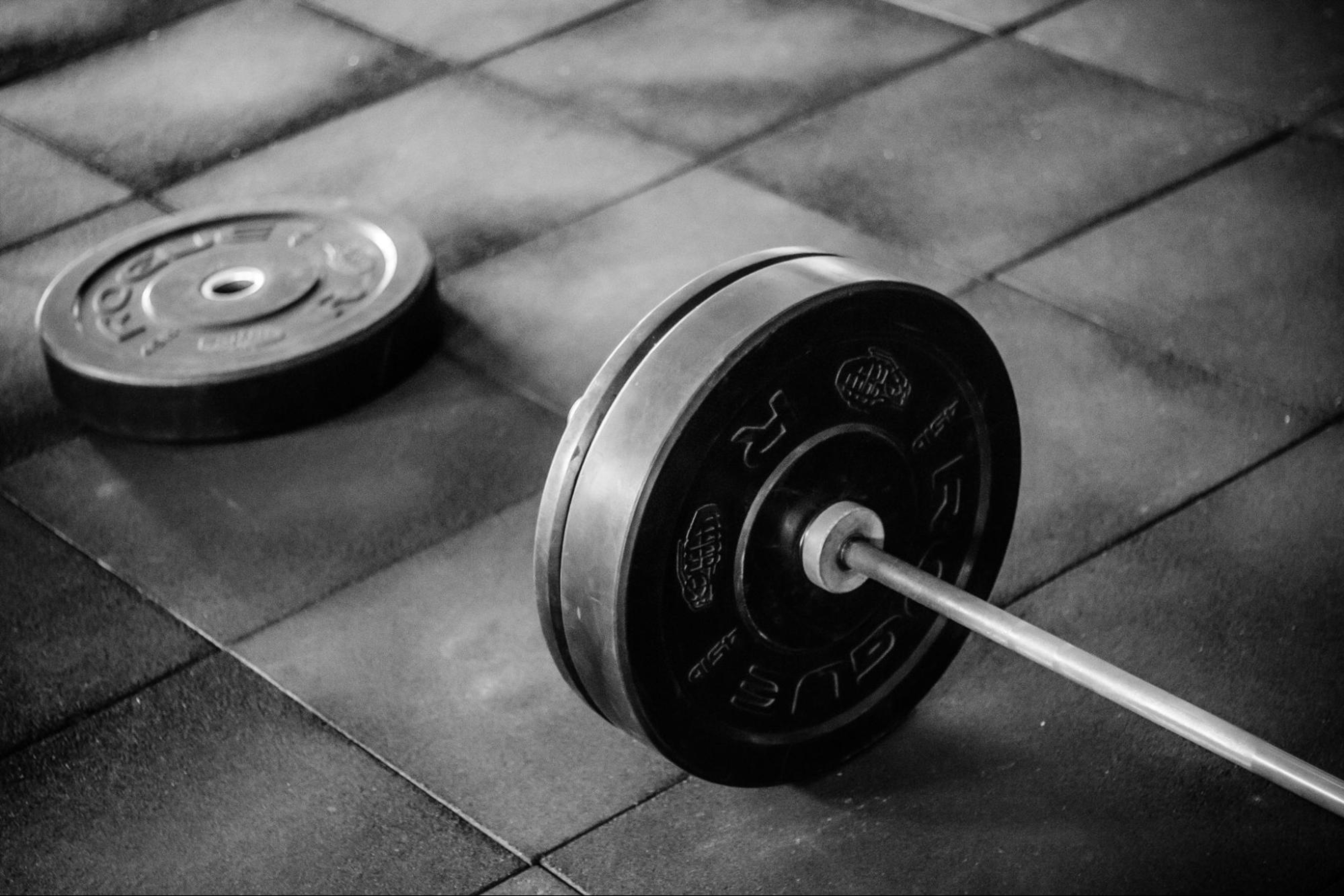Dumbbells on the floor of a gym, representing a traditional strength training workout.