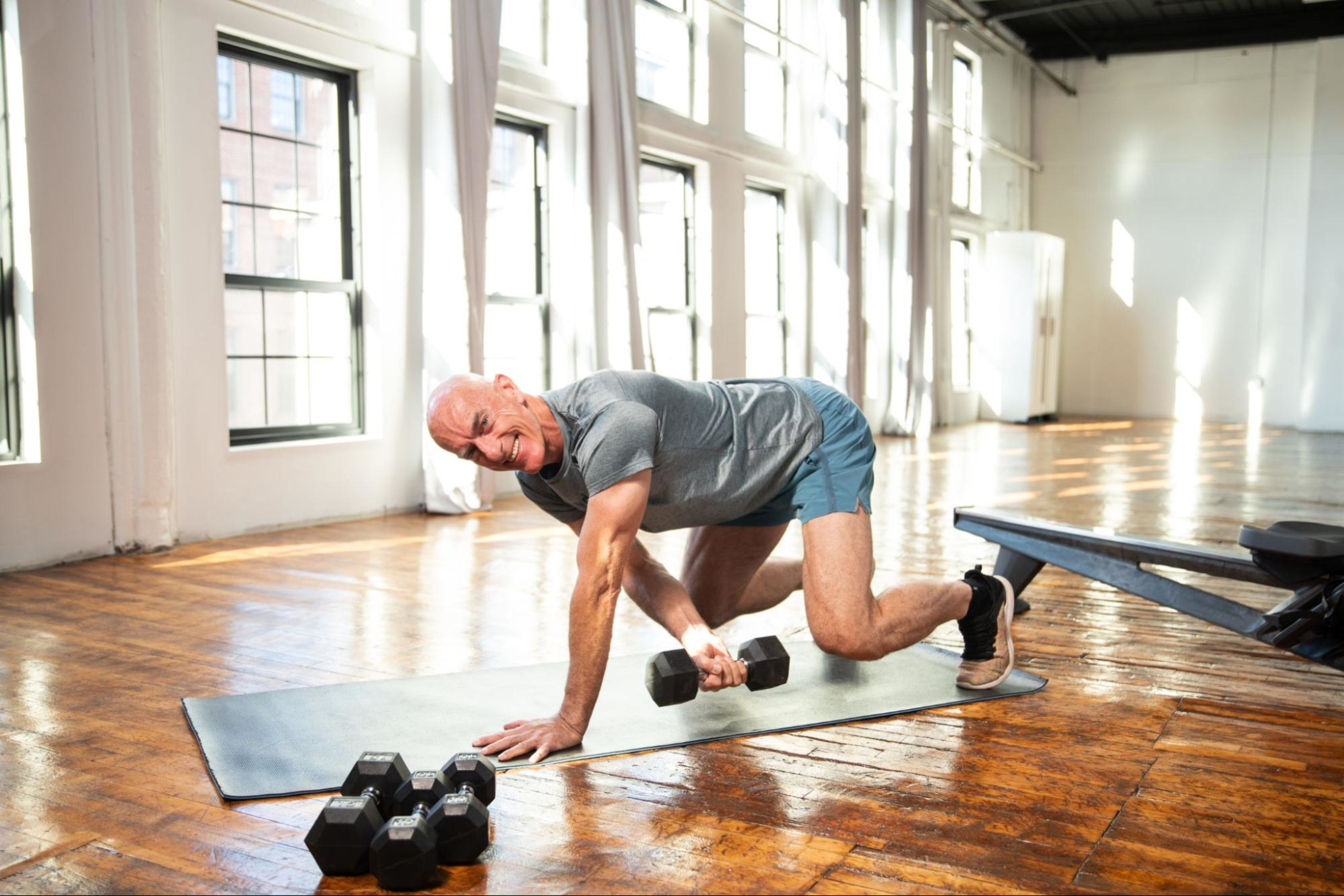 Man does strength training exercises with dumbbells to help improve his running.