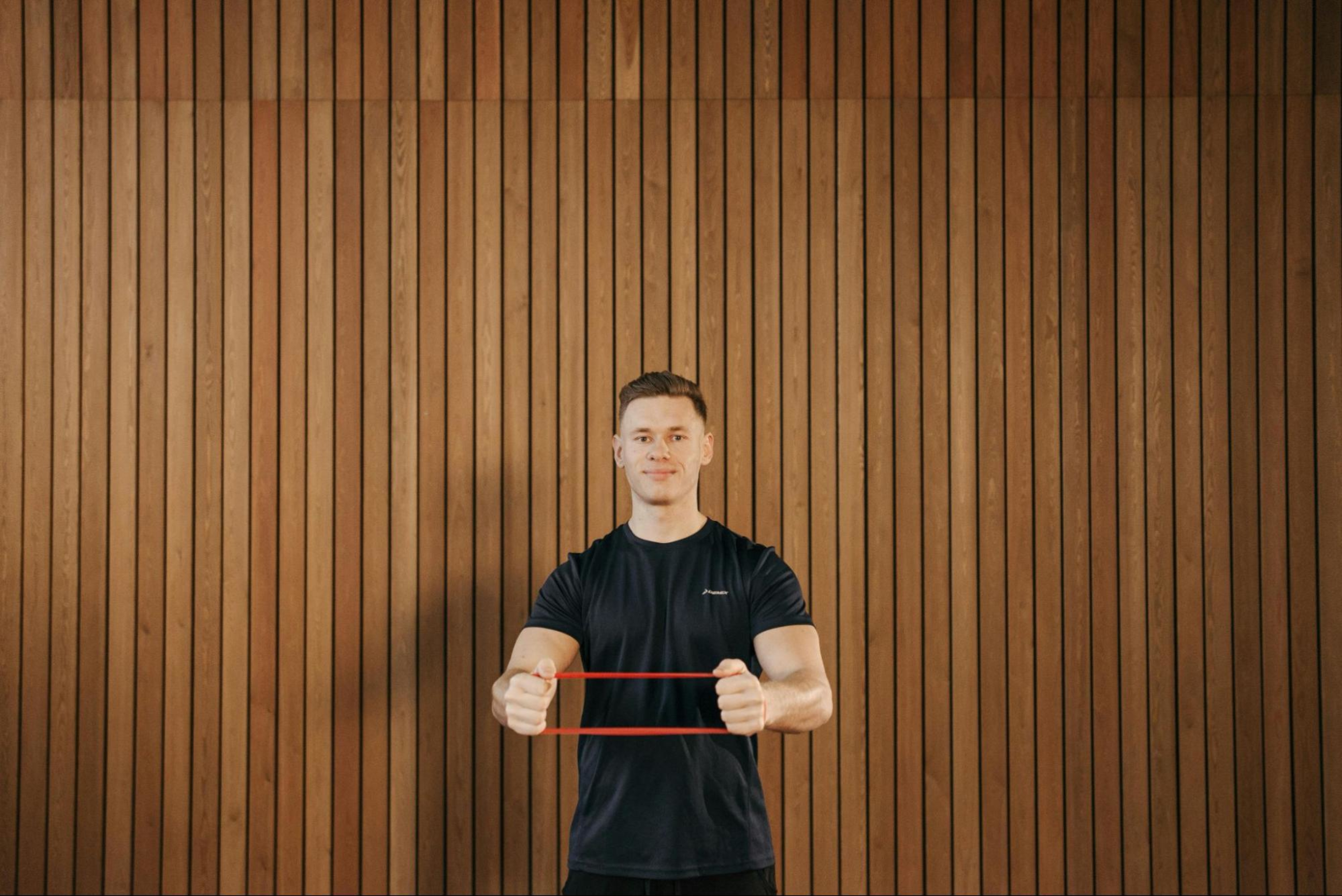 Man does strength training exercises with a resistance band to help improve his running.