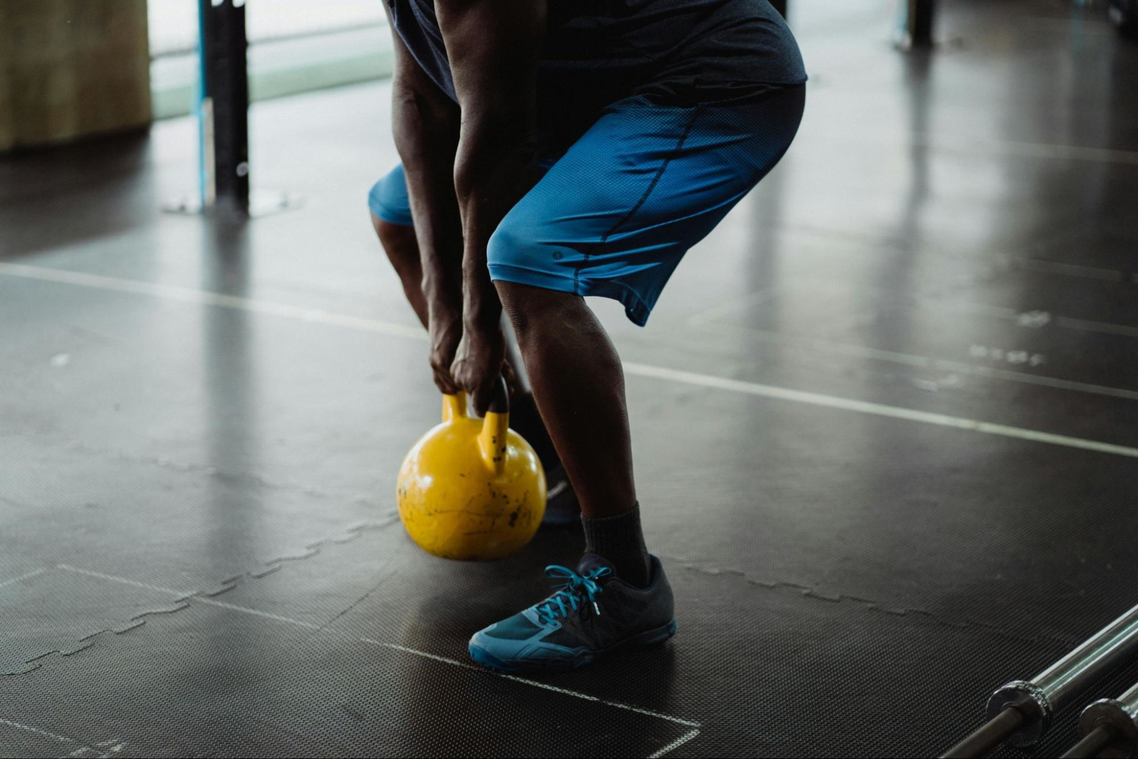 Man does strength training exercises with a kettlebell to help improve his running.