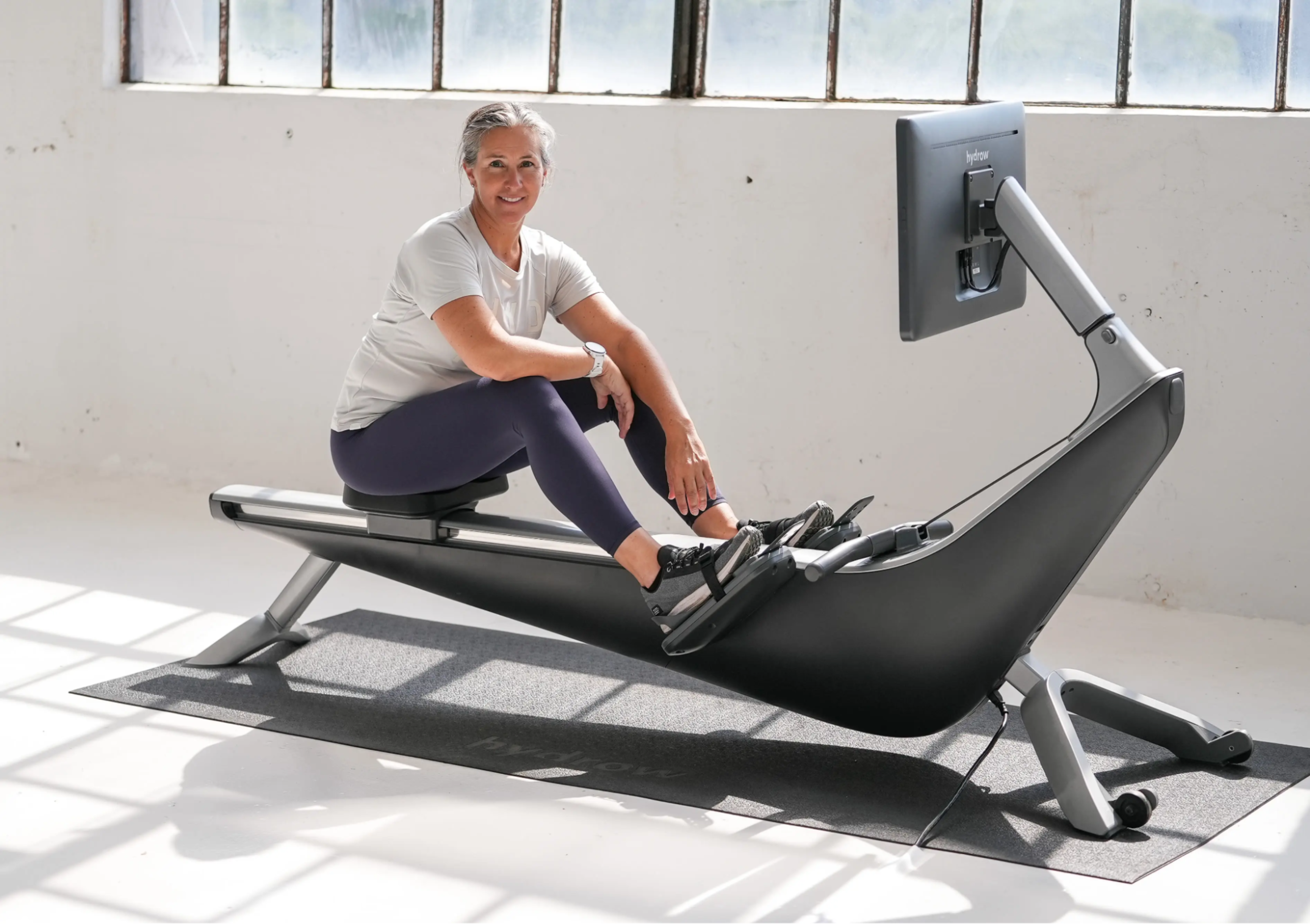 Megan Hanewald, Hydrow's lead personal coach, sits on a Hydrow rowing machine.