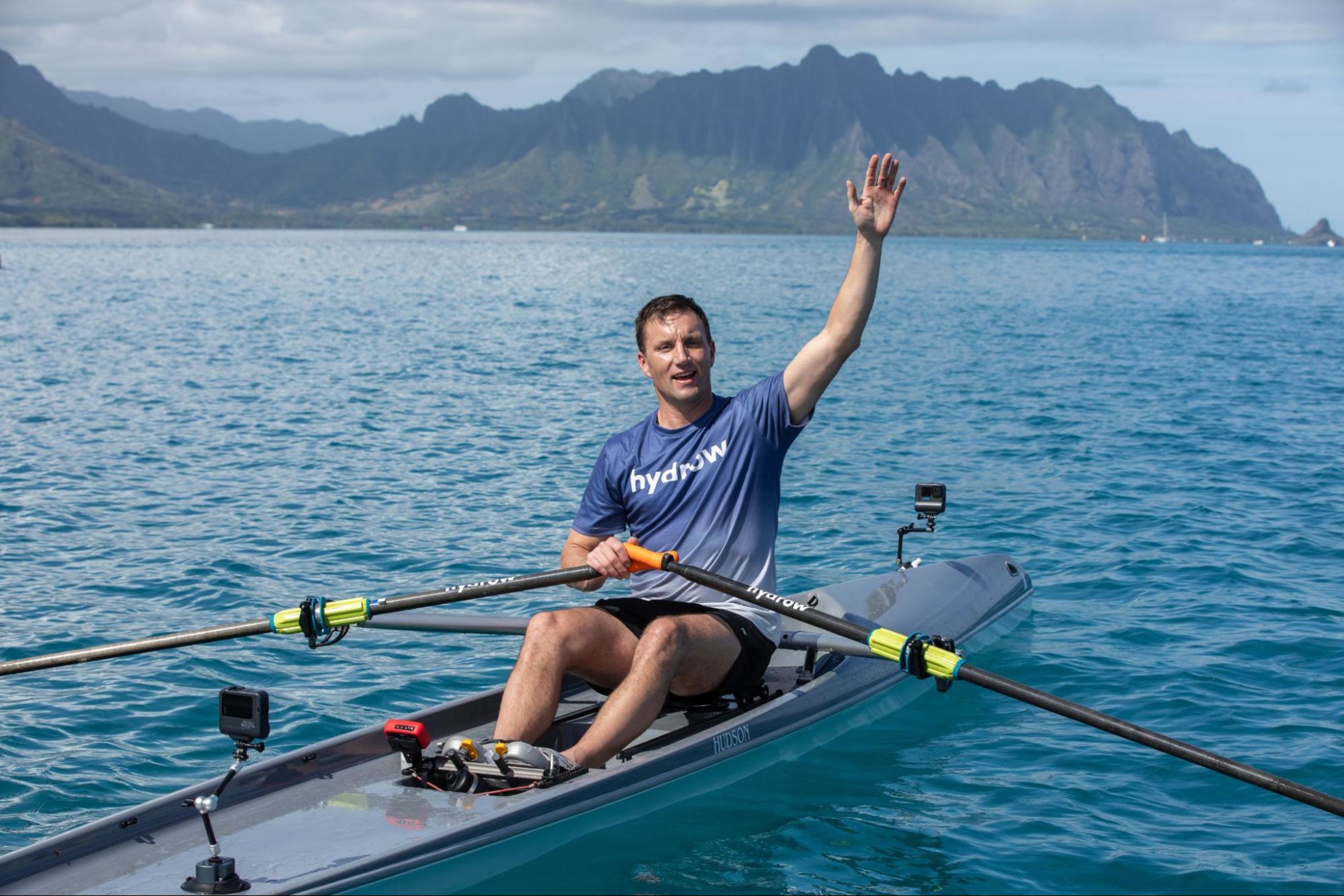 Hydrow Athlete waves from the water in Hawaii.