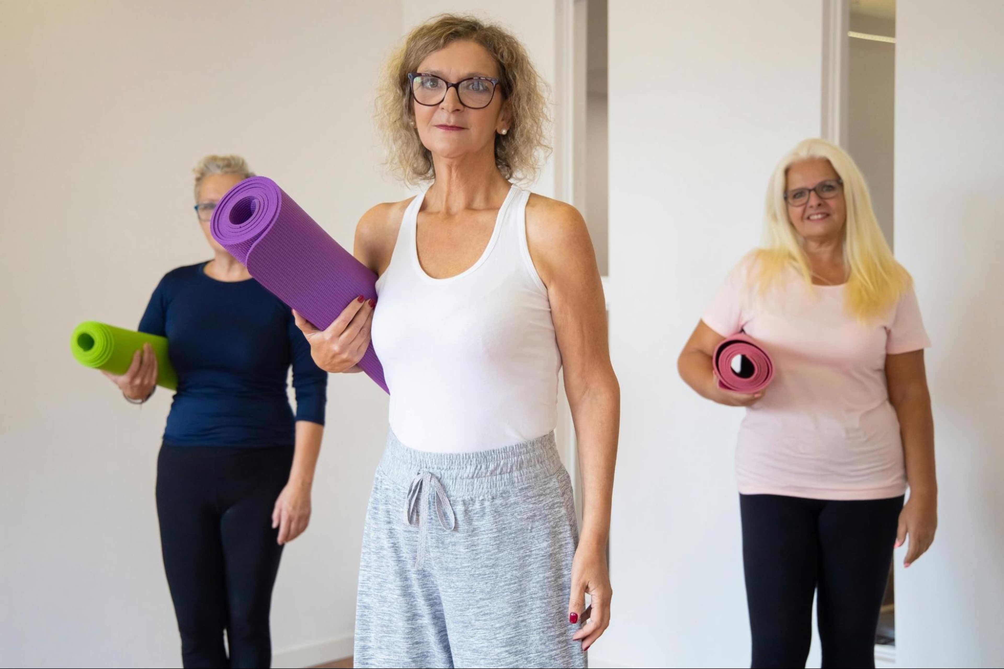 A group of women prepare to do strength training exercises after 50.