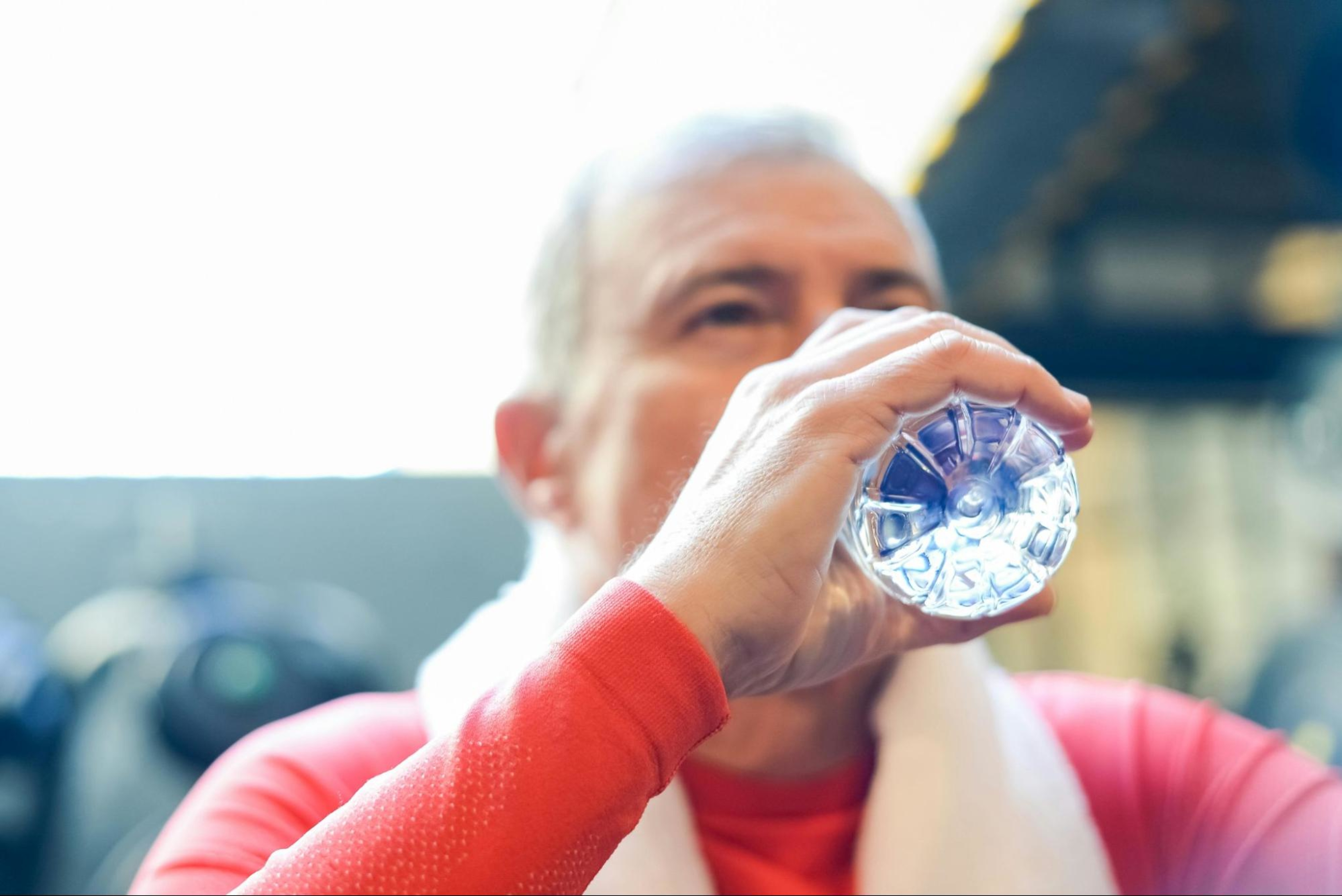 Man drinks water to recover from doing low-impact strength training exercises.