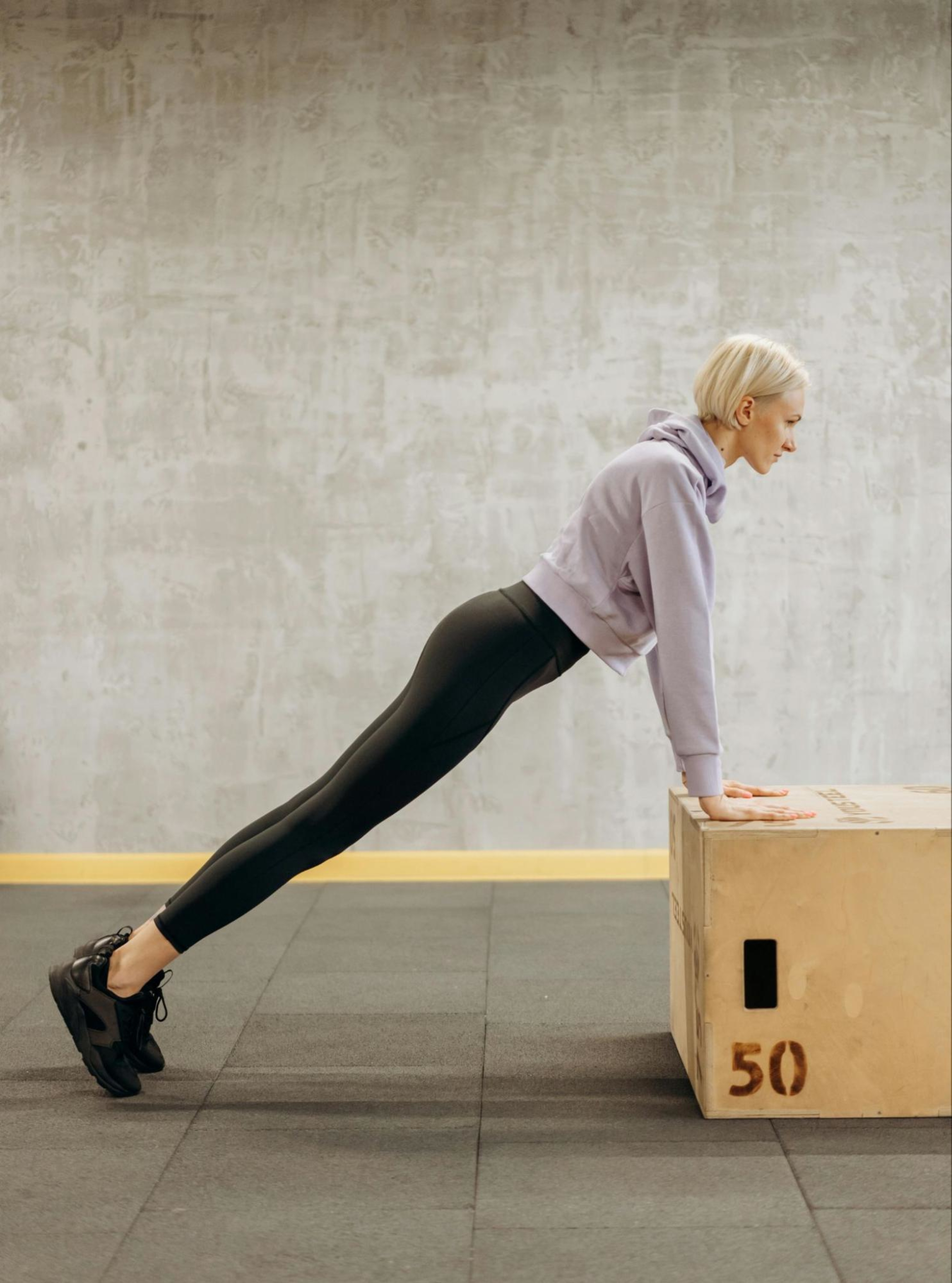 Woman does box push-ups, an example of a low-impact strength training workout.
