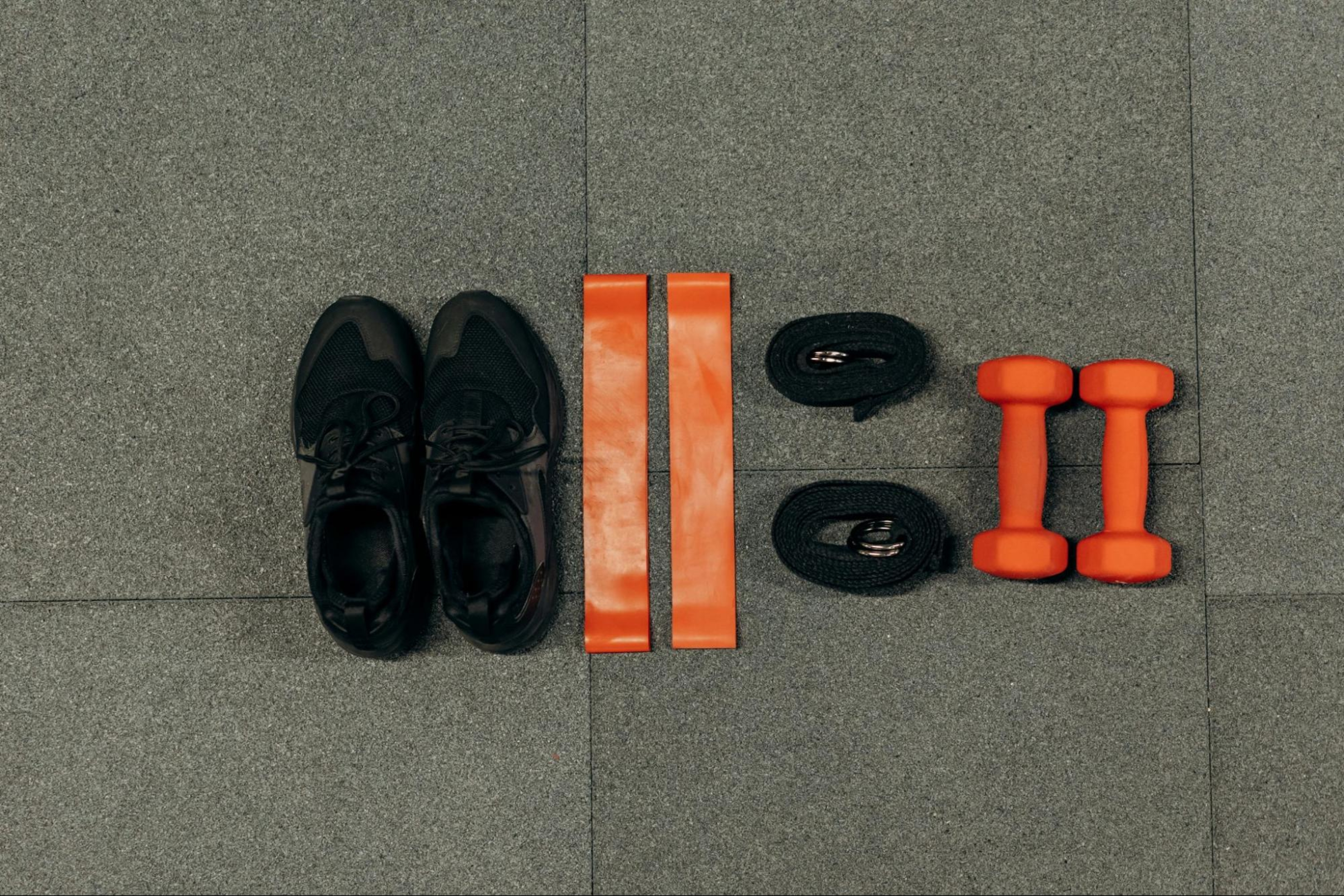 Low-impact strength training equipment, including sneakers, resistance bands, straps, and dumbbells.