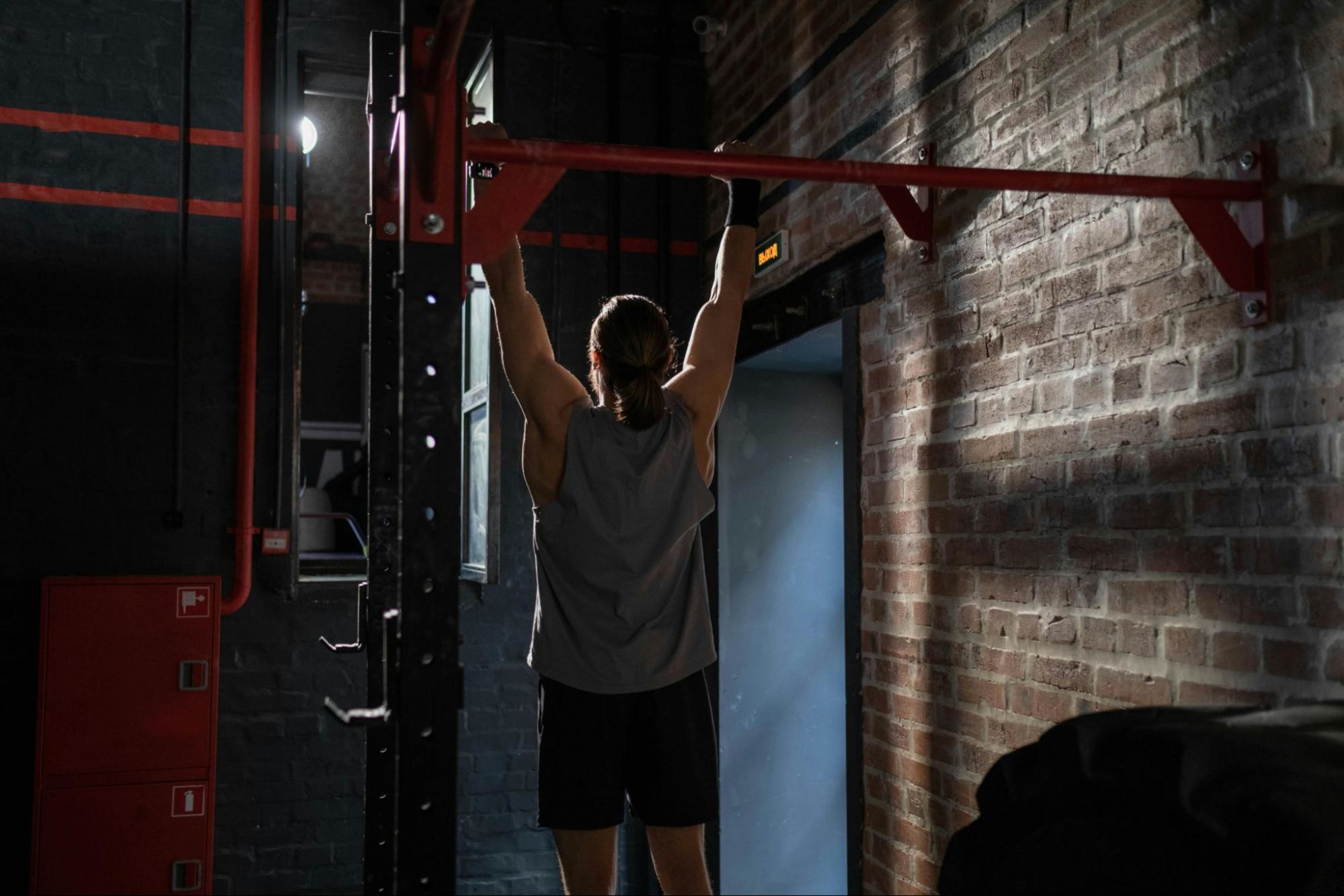 Man does exercises in a gym for building muscle in forearms.