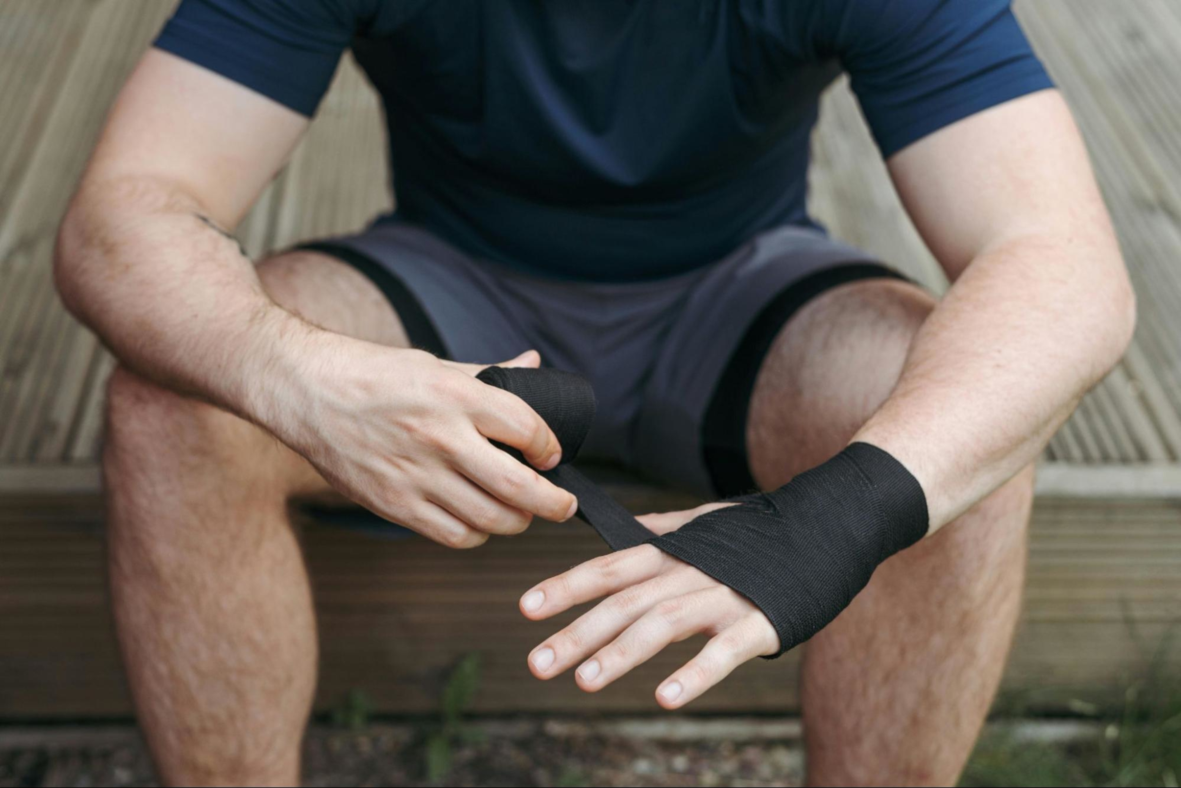 Man wraps tape around his hand after learning tips for building forearm muscle.