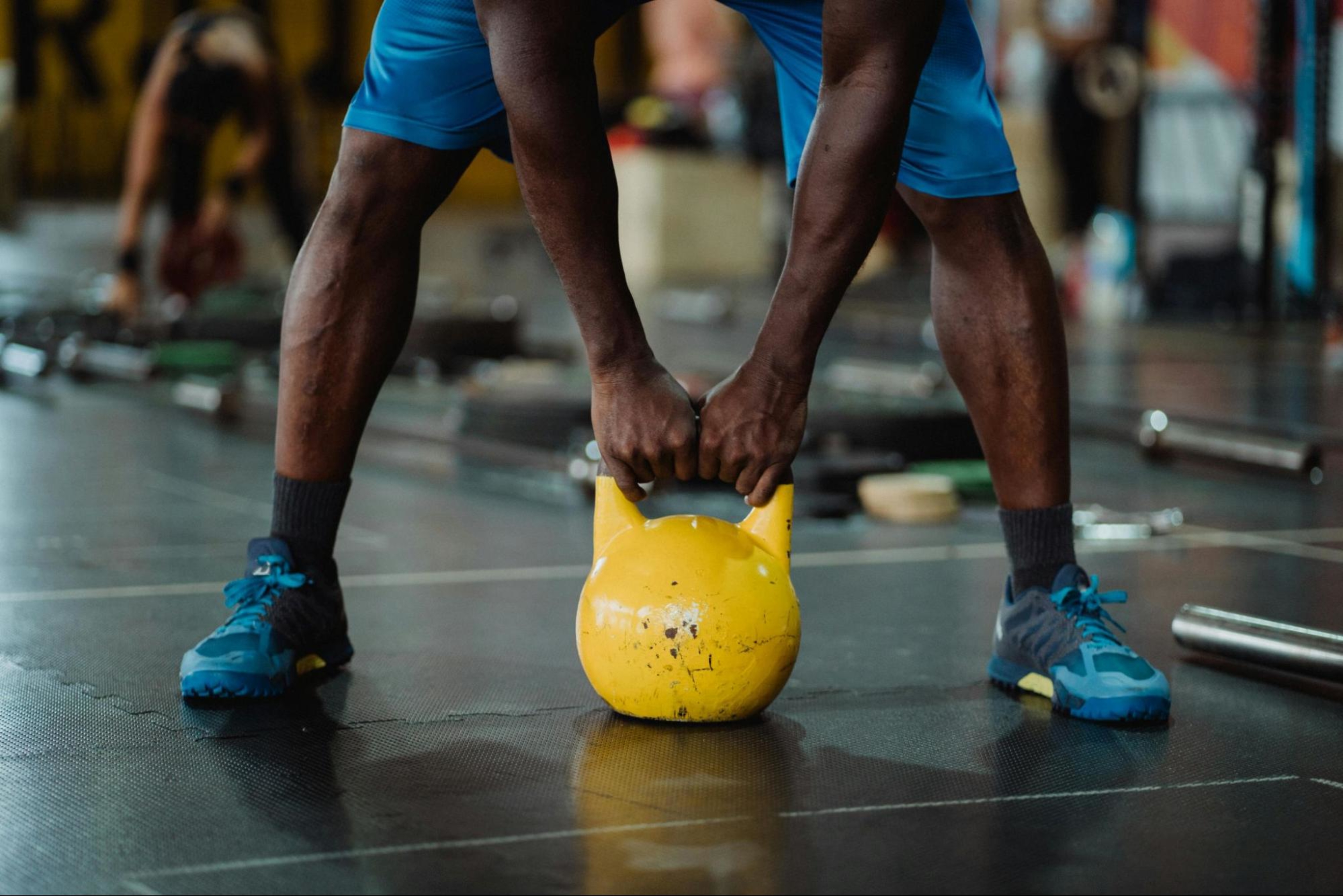 Man prepares to lift a kettlebell to do one of the best thigh workouts.