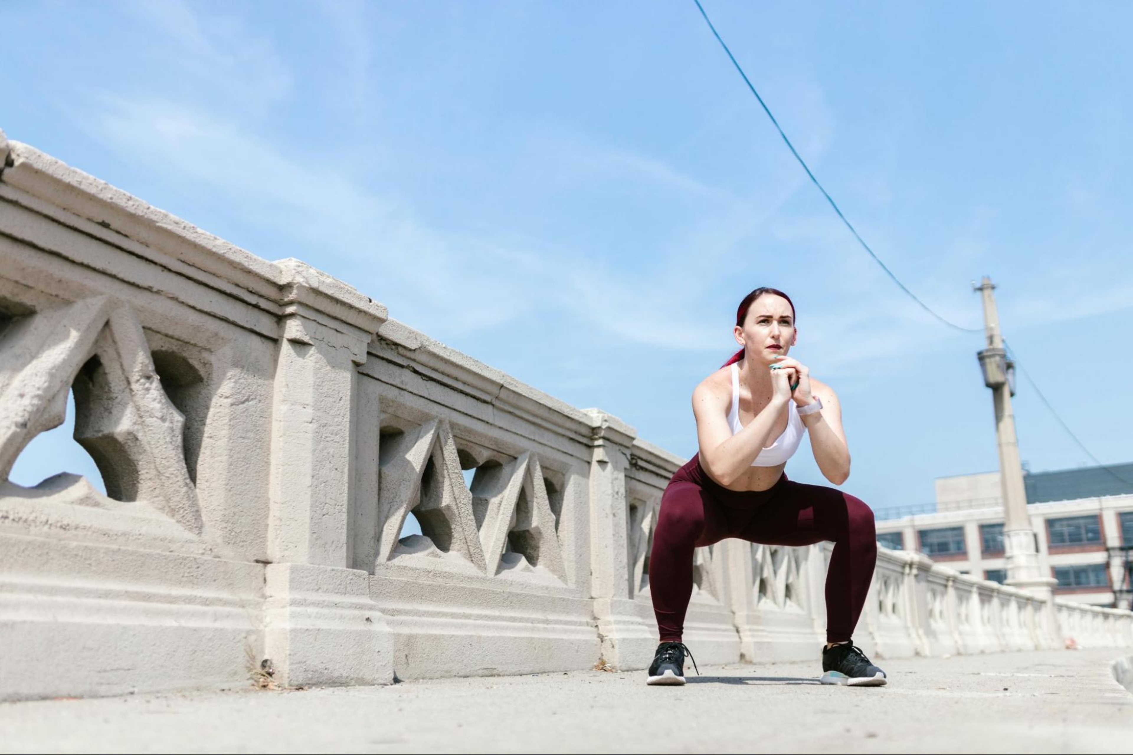 Woman does a squat, known as one of the best exercises for thighs.