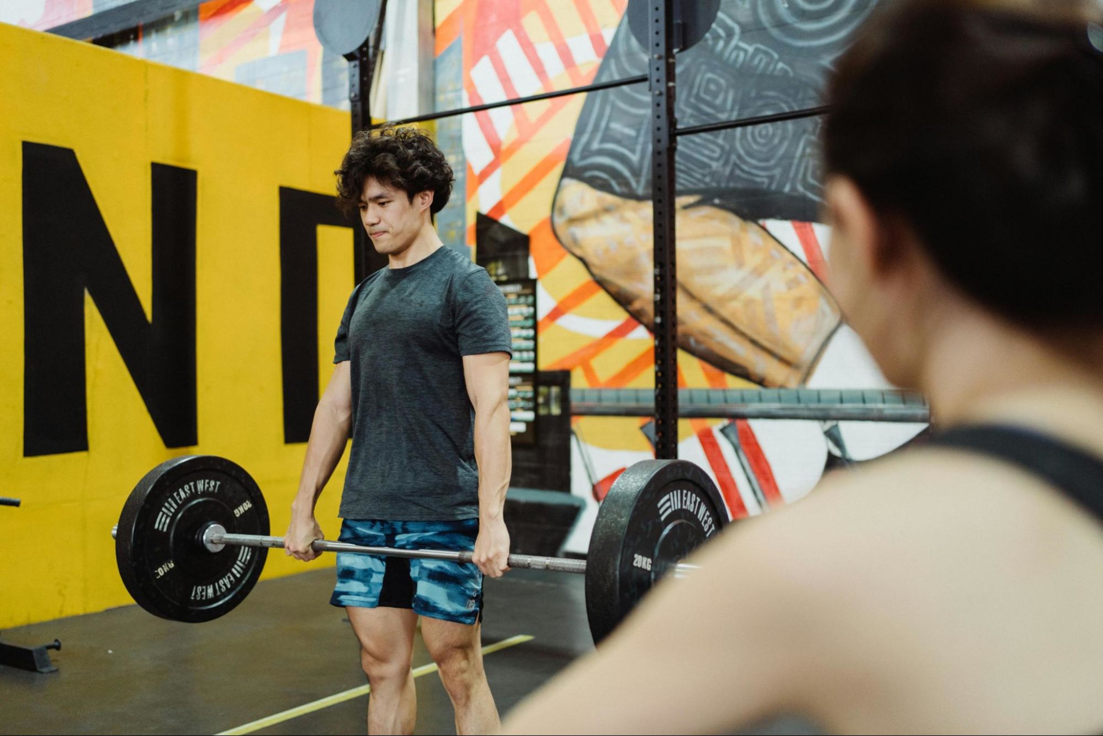 Man does a barbell workout to work his thighs.