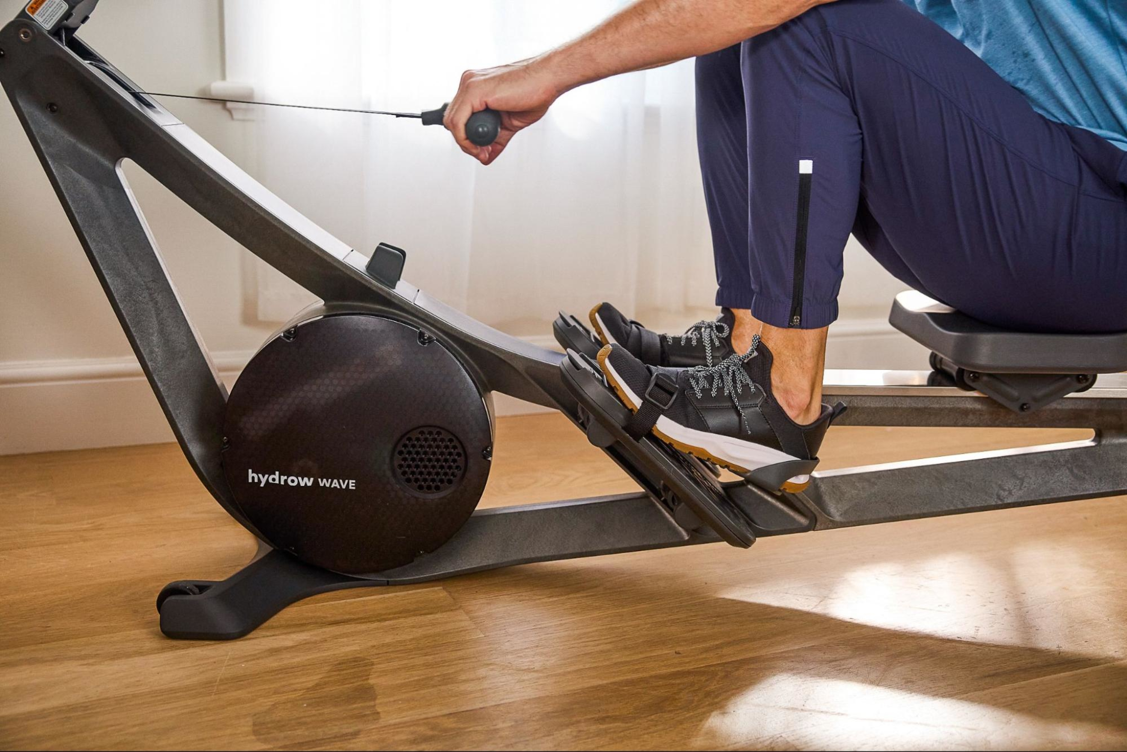 Man works out on a Hydrow rowing machine, with a special emphasis on the comfortable footplate.