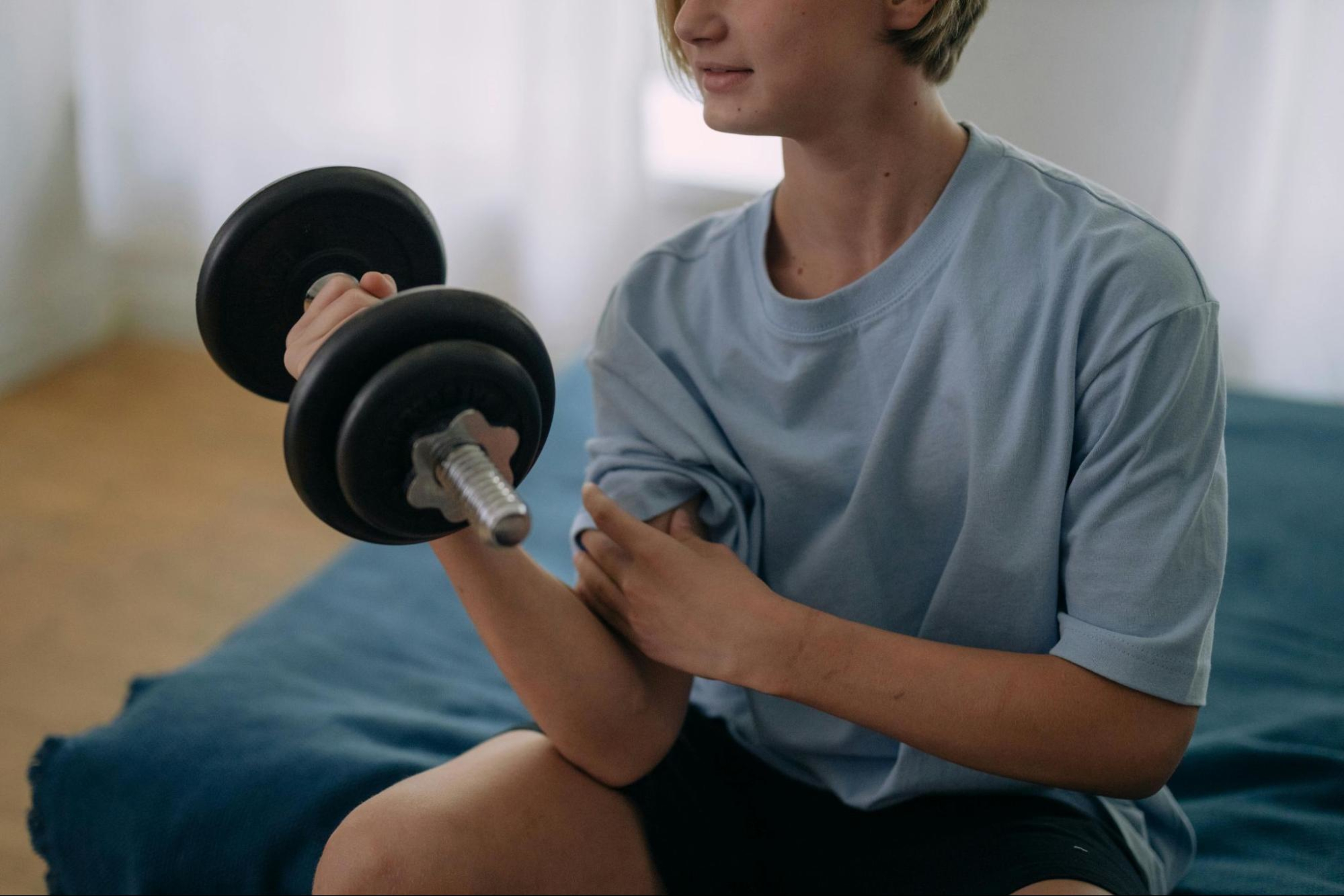 Woman learns how to get arm muscles by doing bicep curls with a dumbbell.