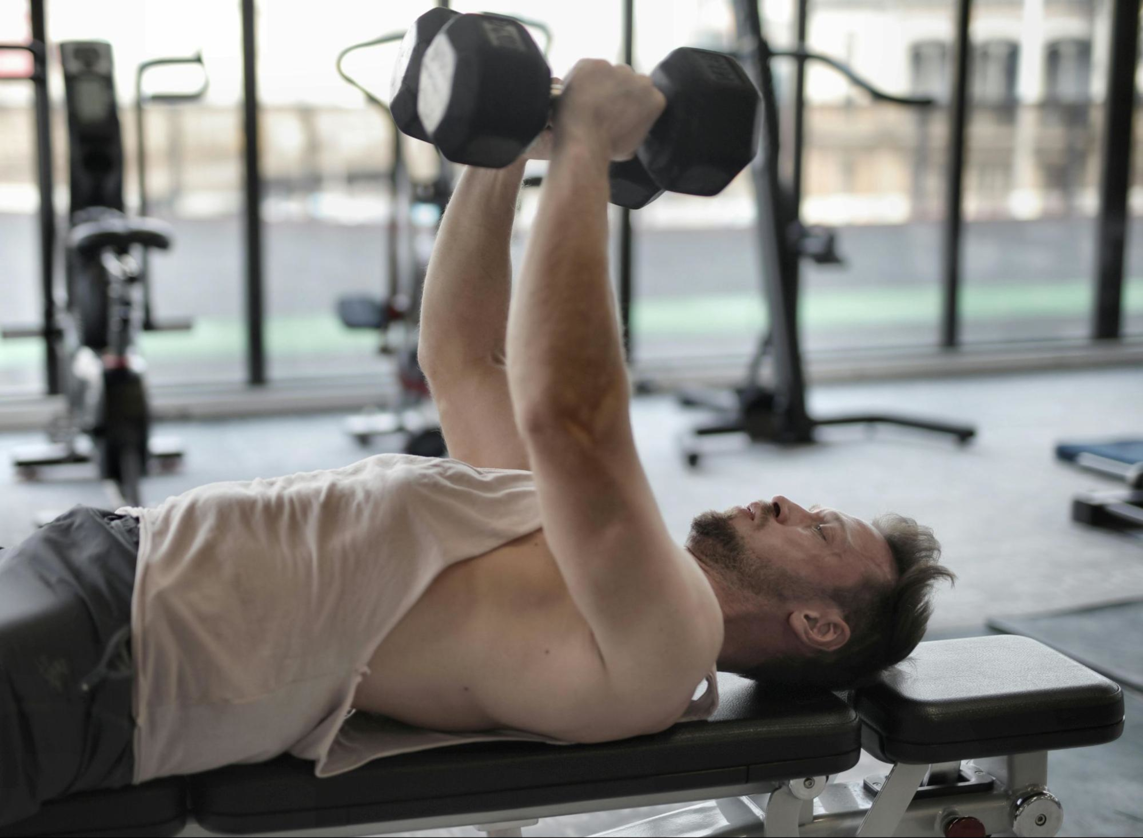 Man learns how to breathe when doing weights while lifting two dumbbells.