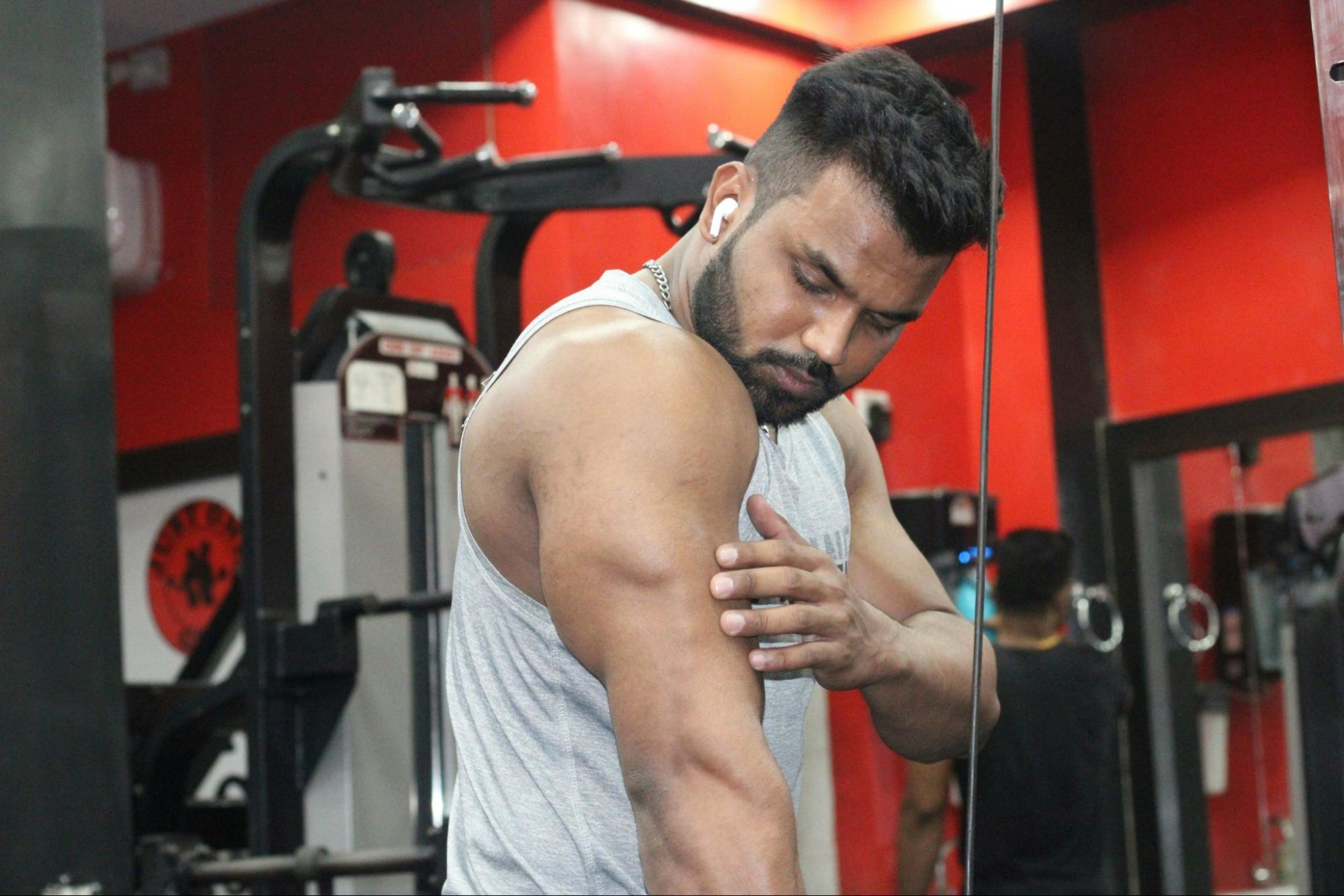 Man admires arm muscle after doing good biceps workouts to build muscle and strength.