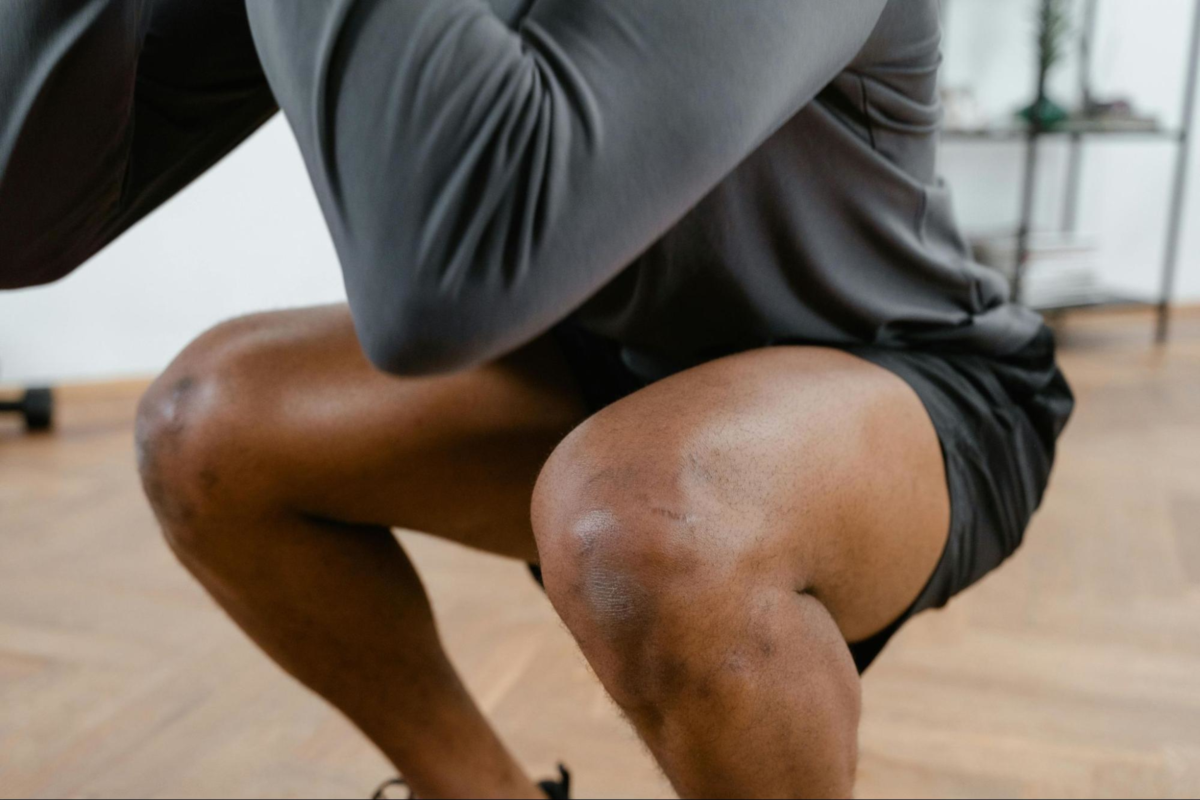 Man builds leg muscles by doing squats.