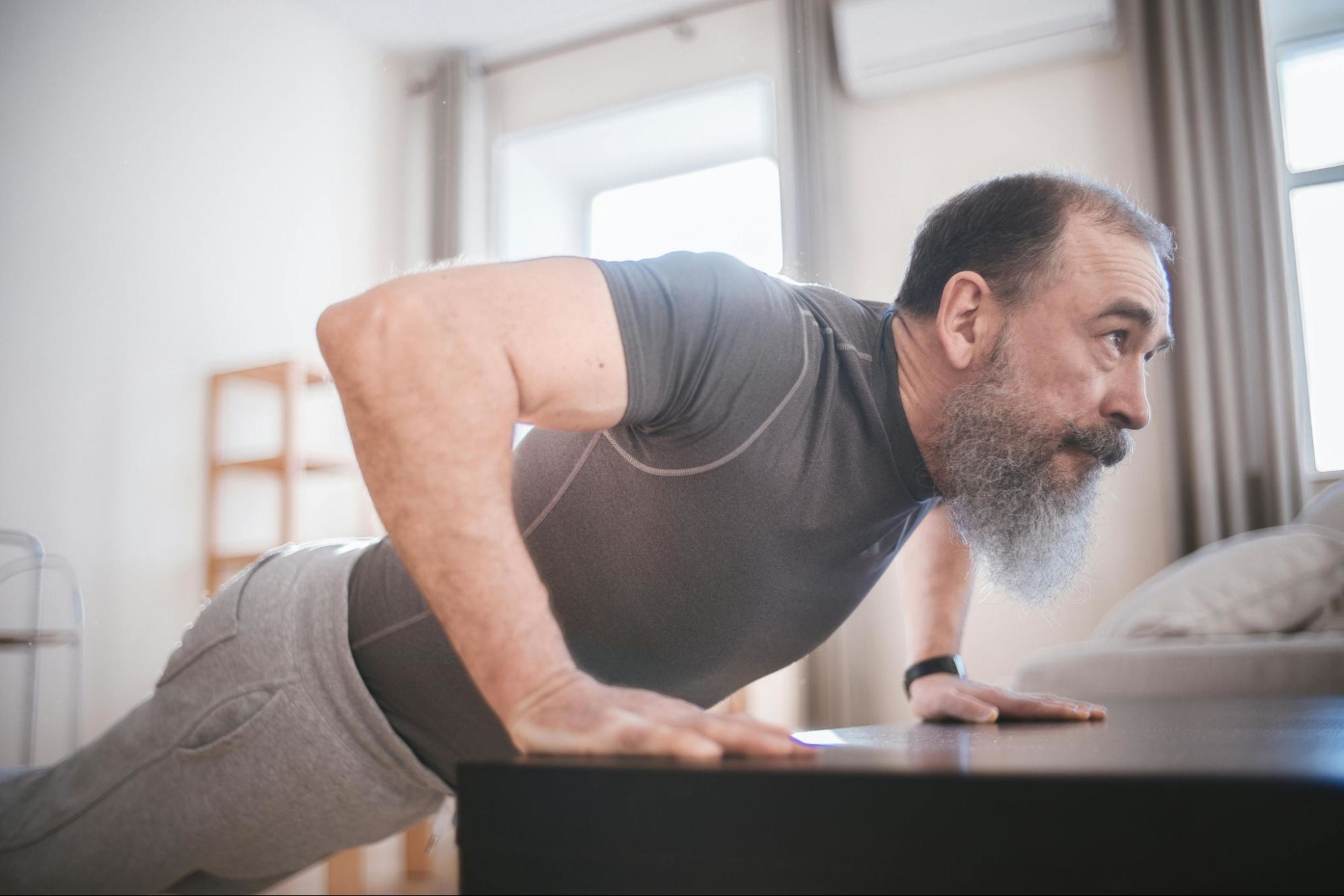 Man does a strength training workout at home to lower his blood pressure.