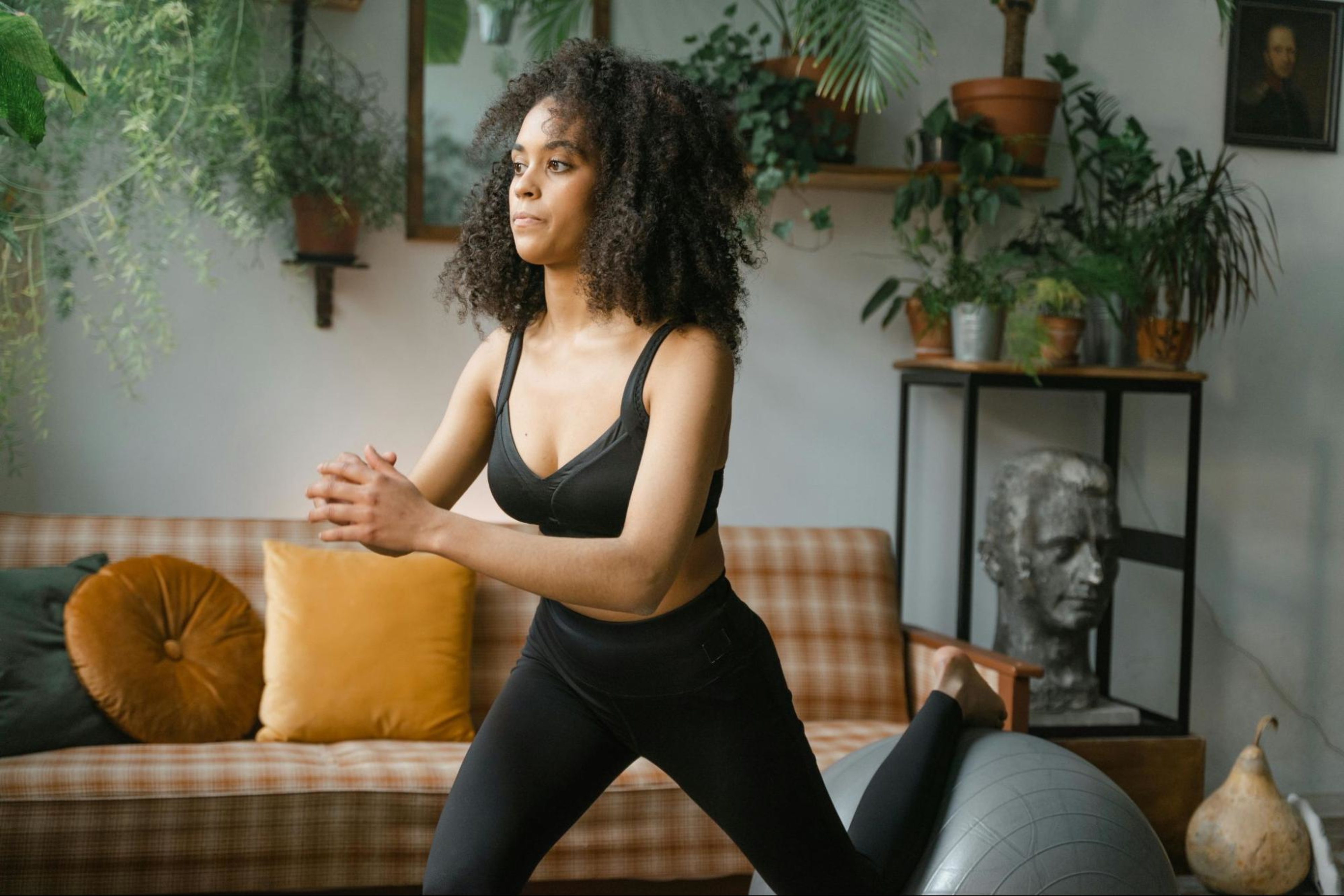 Woman does a basic leg workout at home using an exercise ball.