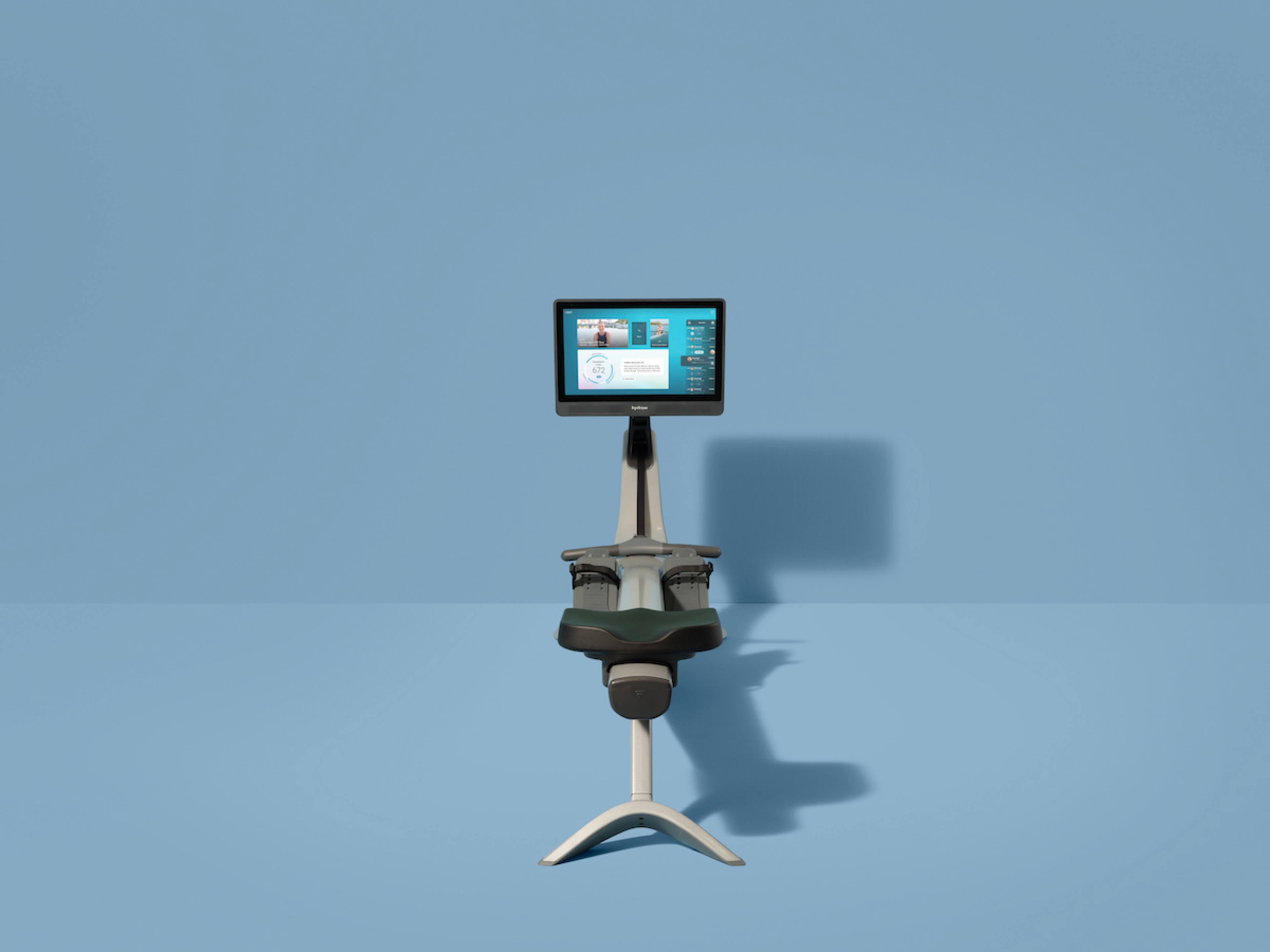 A Hydrow Arc rowing machine against a blue background.