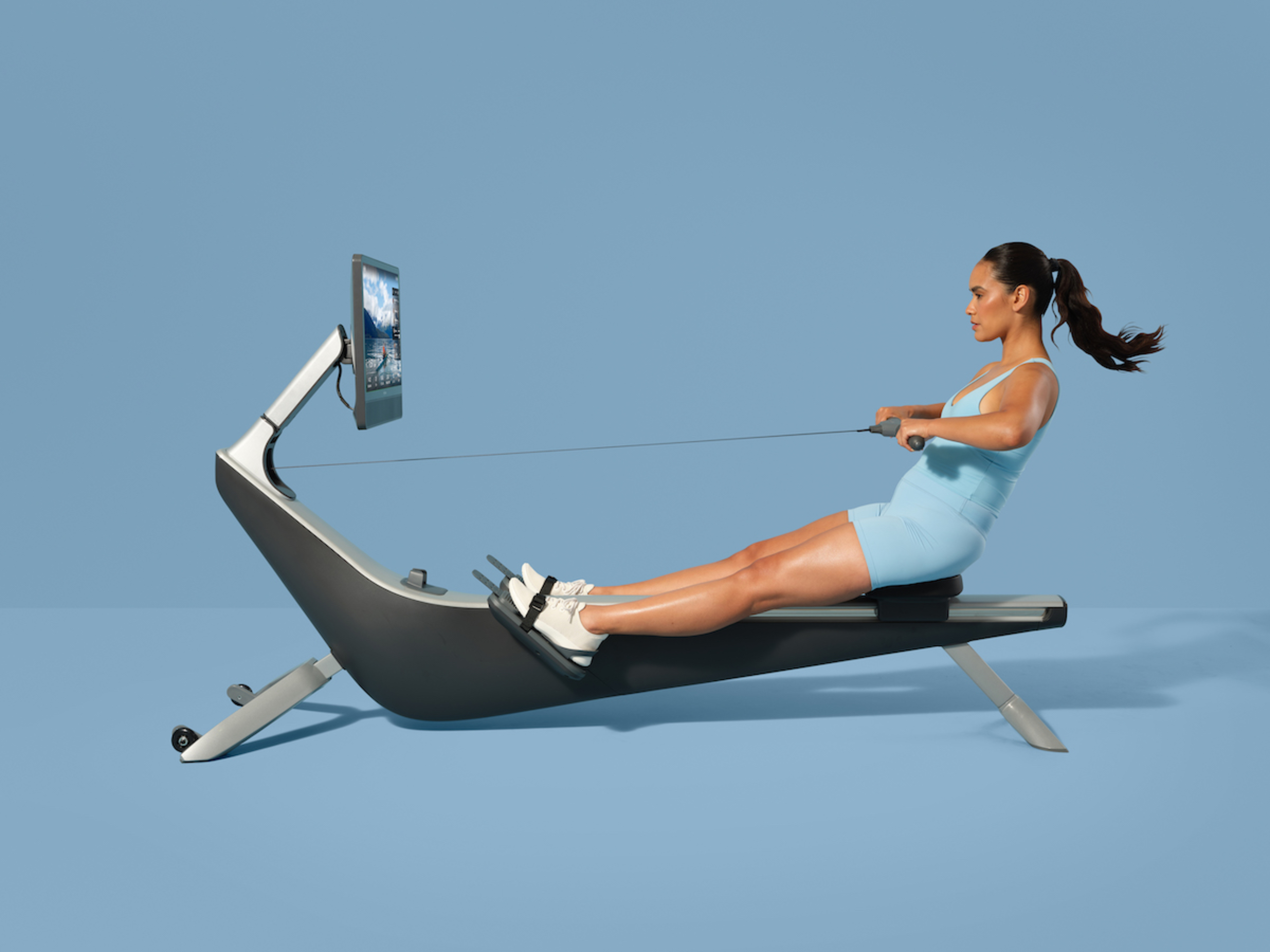A woman works out on a Hydrow Arc rowing machine.