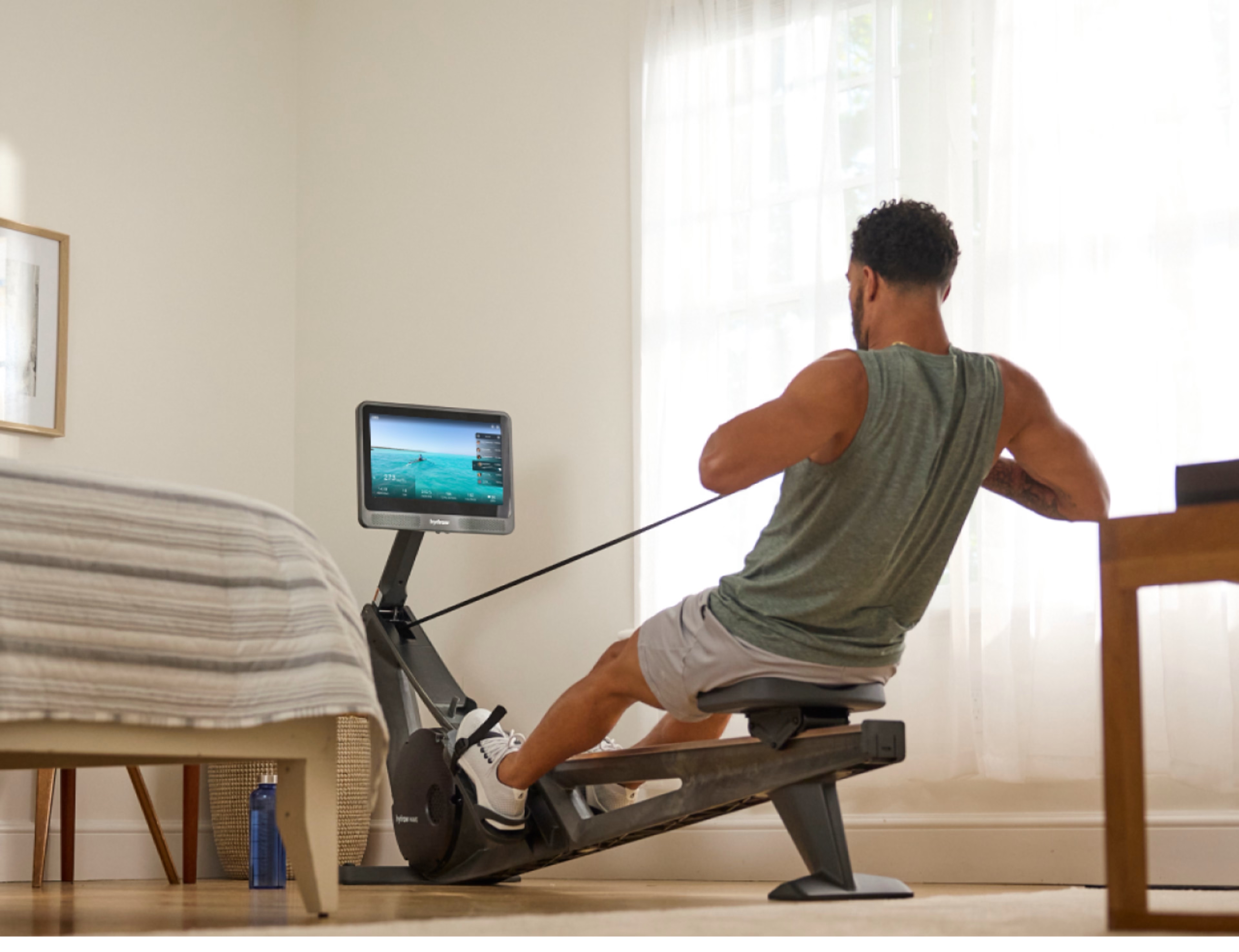 Man works out on a Hydrow Wave rowing machine.