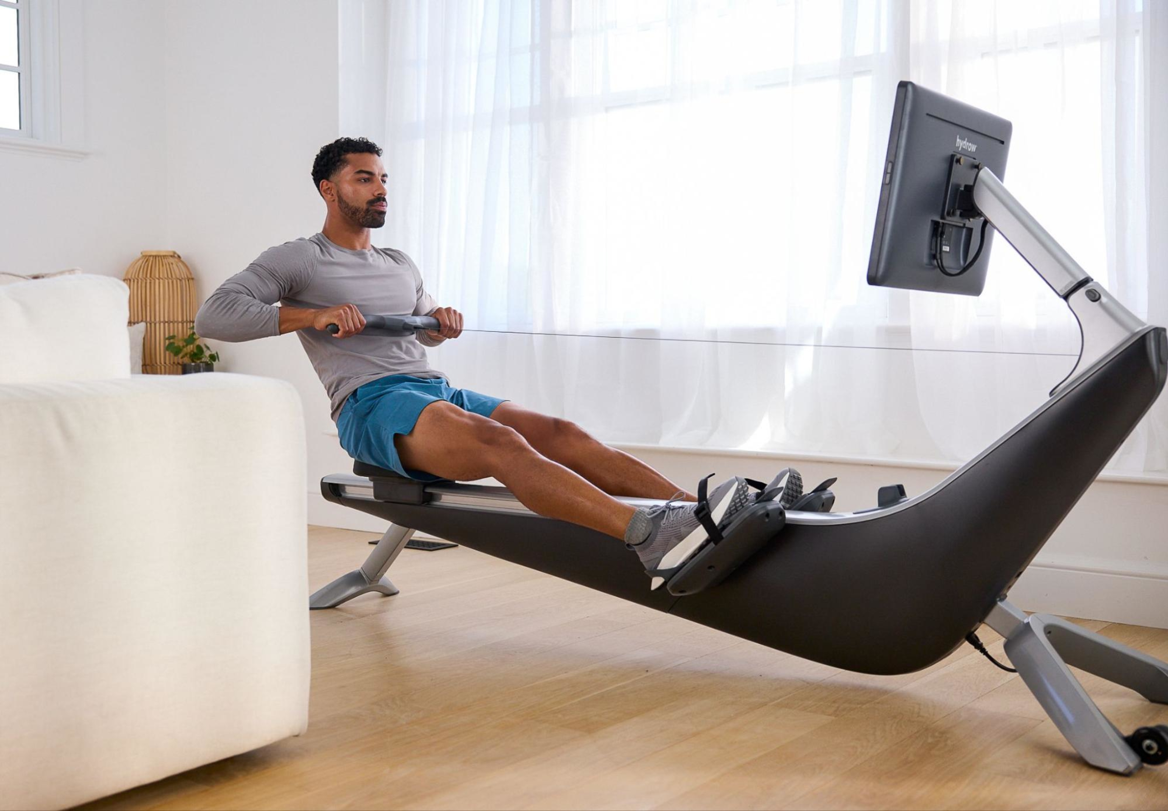 Man works out on a Hydrow Origin rowing machine.