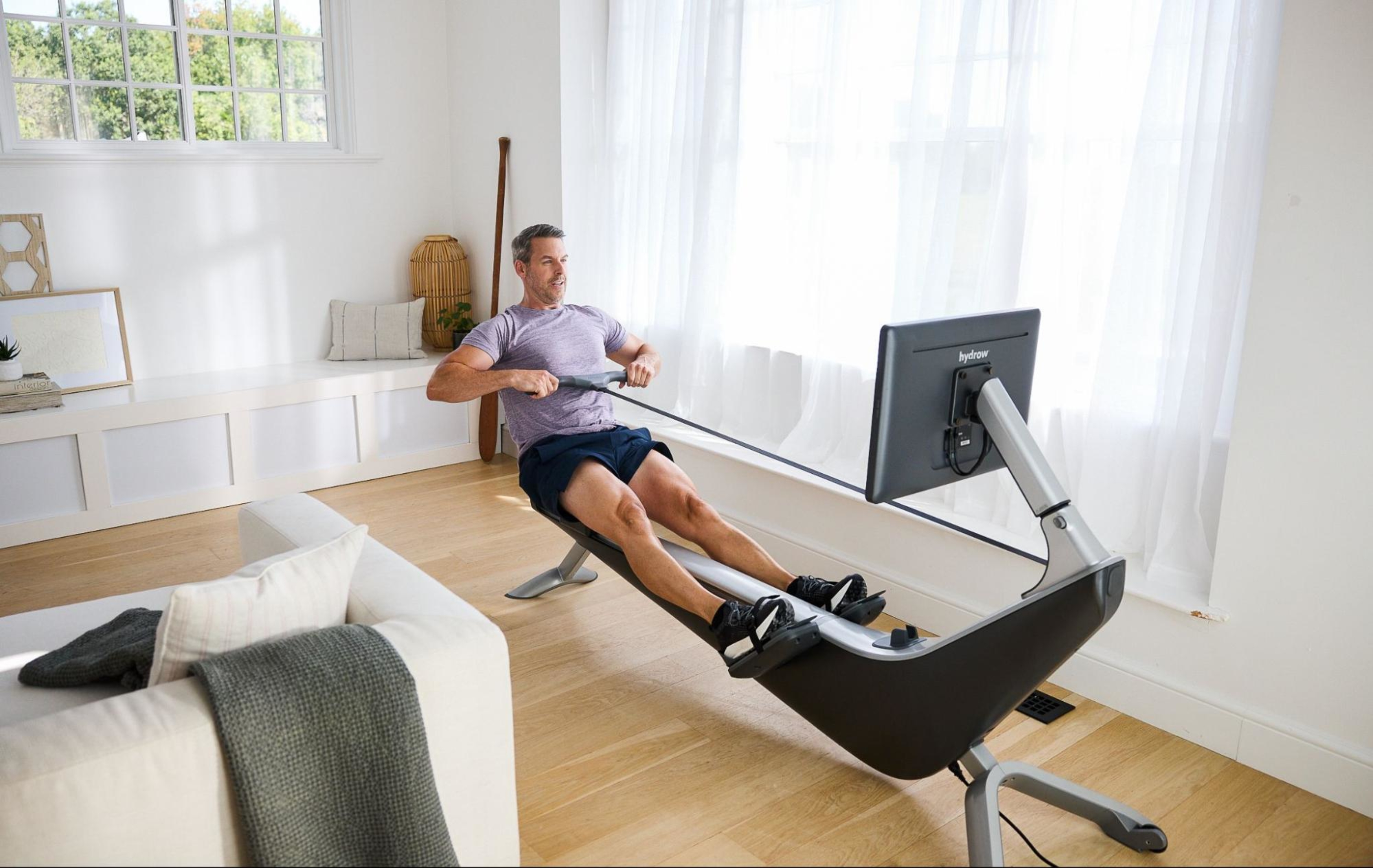 Man works out on a Hydrow Origin rowing machine, which boasts an on-water feel.