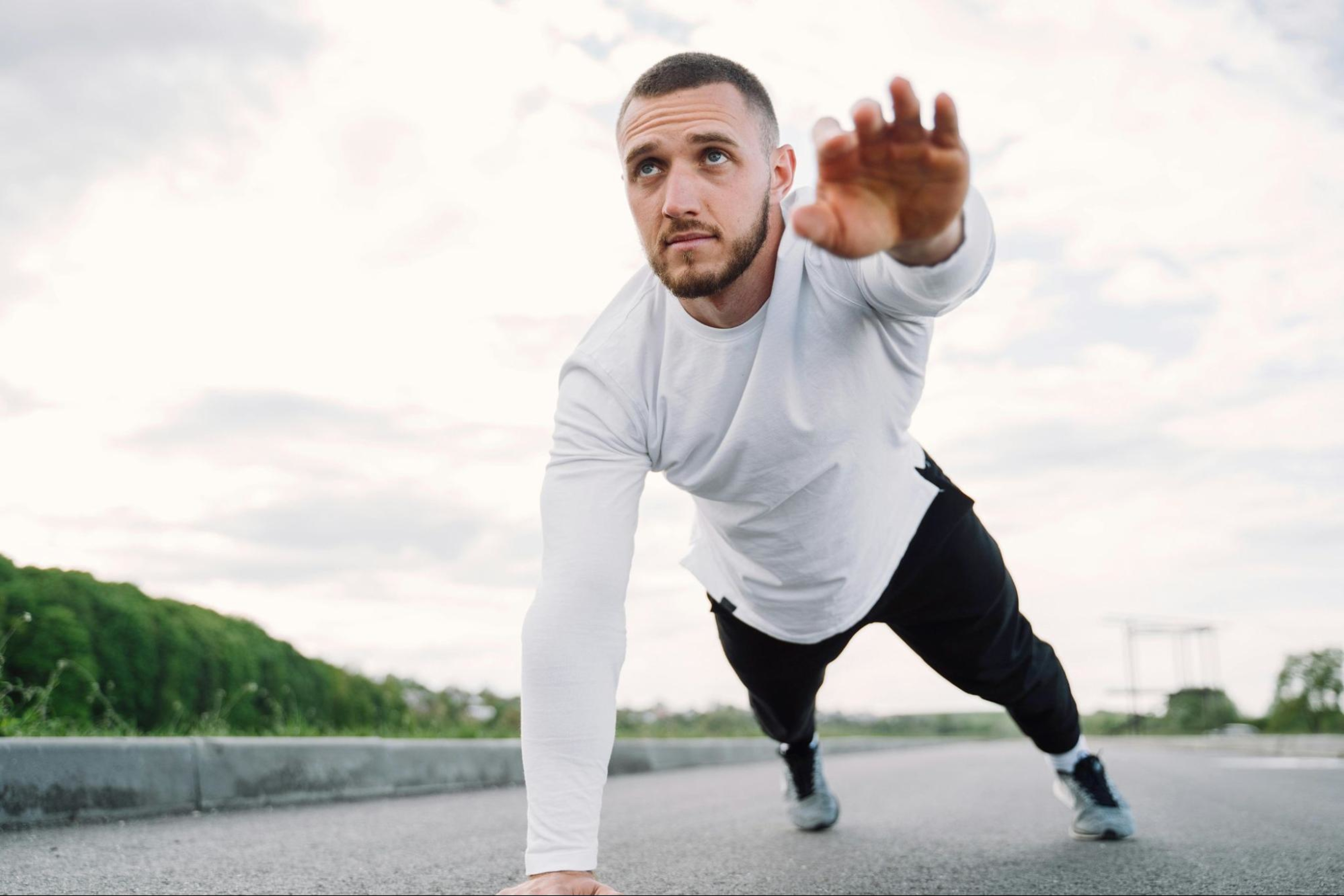 Man does a one-handed plank, one of the best workouts for core strength.