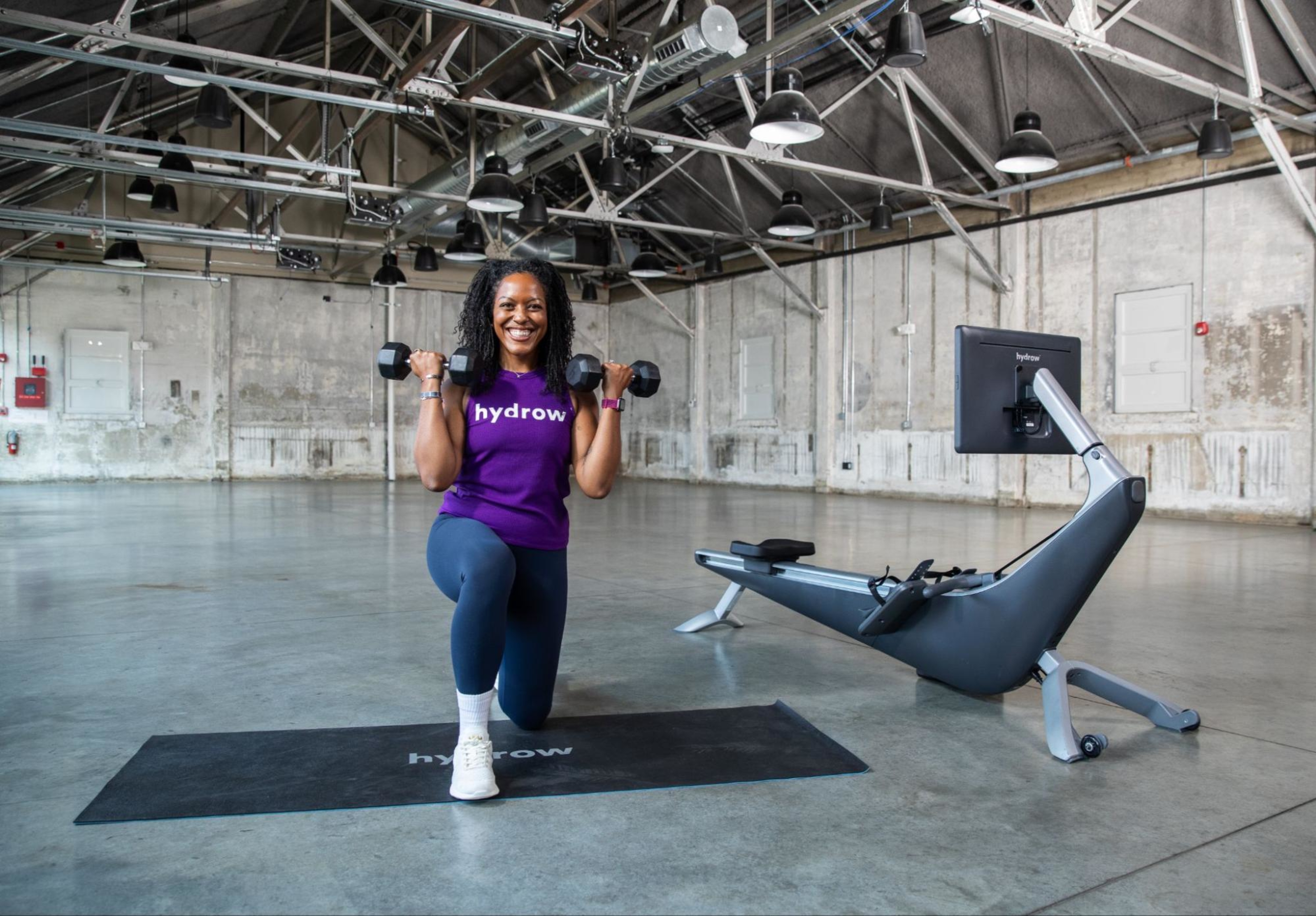 Hydrow Athlete Rina demonstrates strength exercises for swimmers with two dumbbells.